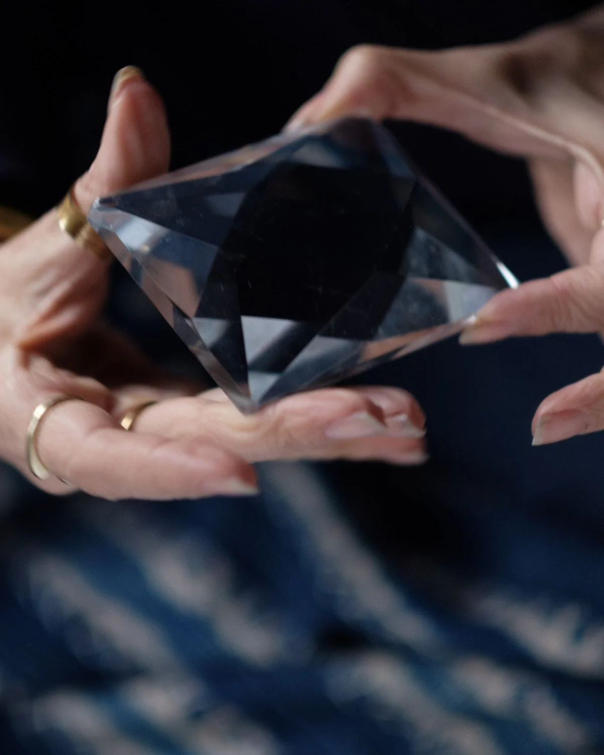 Hands holding a clear crystal prism