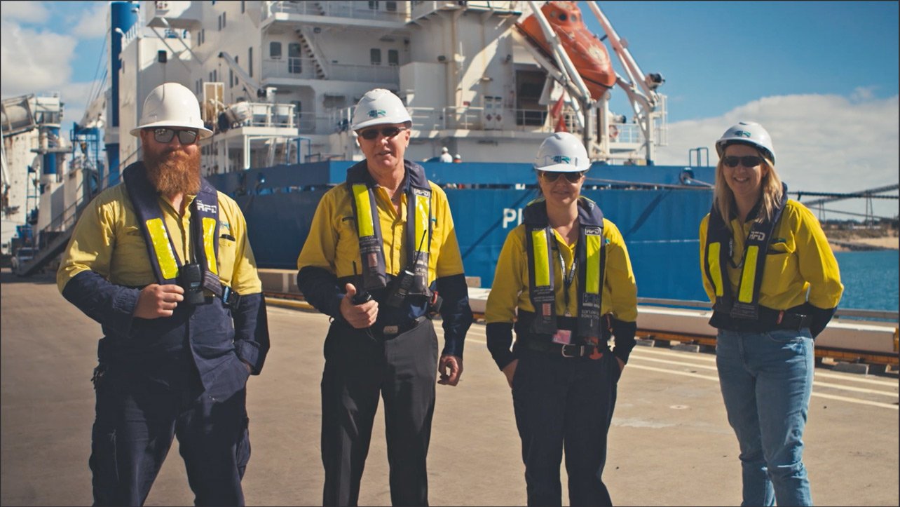 NQBP workers standing in front of a moored ship