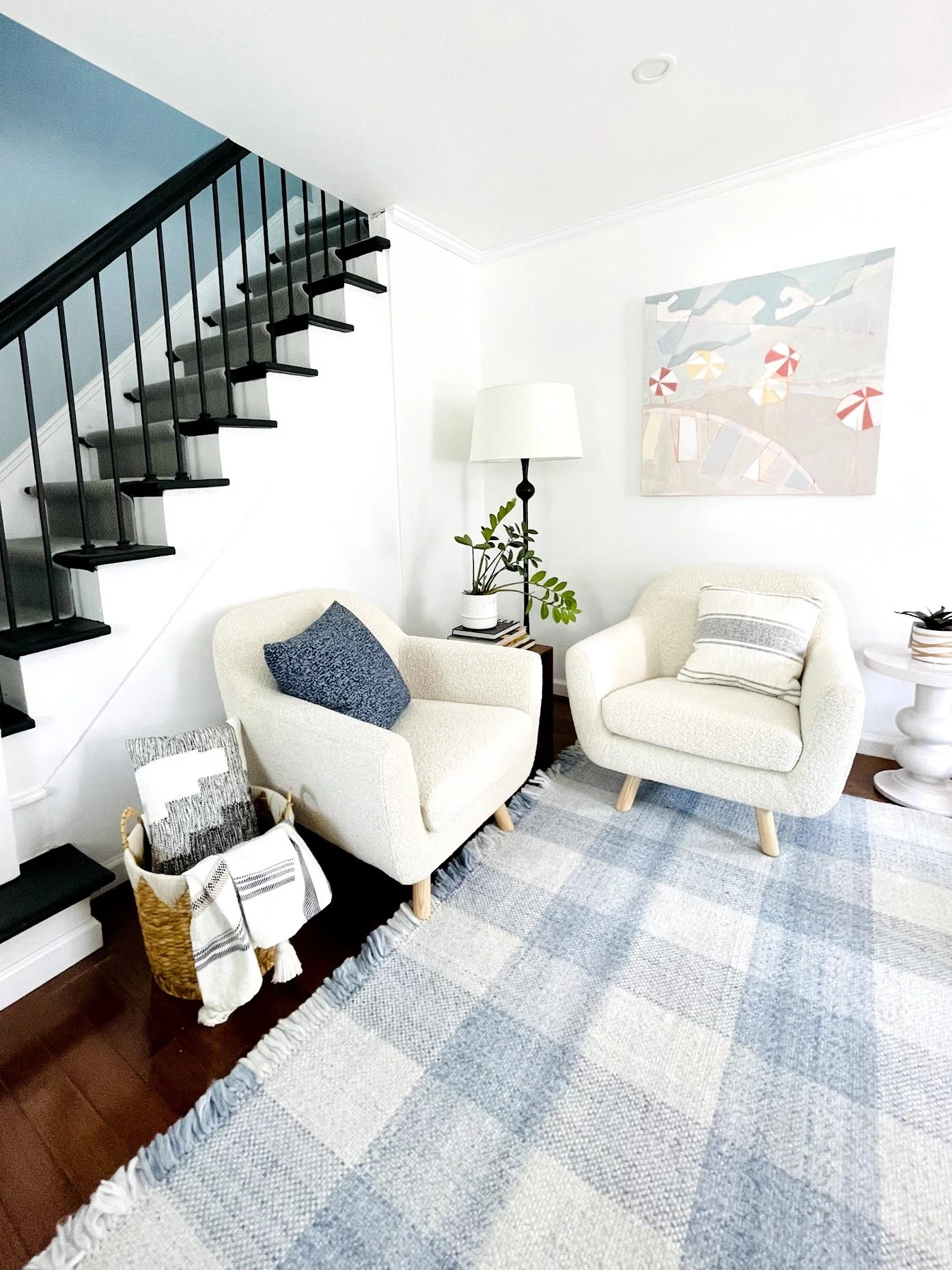 blue white boho living room,  coastal cottage core living room,  gingham rug, Kristen Anton art, Noel Gatts design HGTV