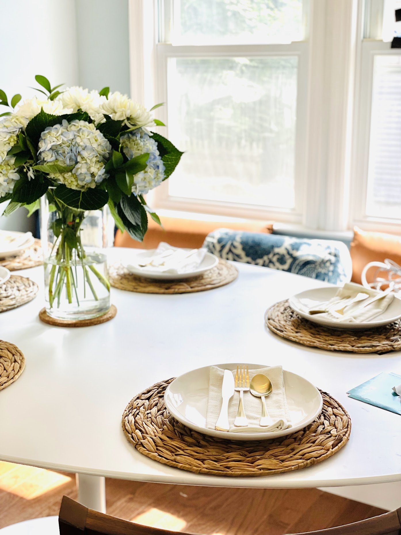contemporary cottage core dining room, woven charger, table setting,  blue white brass dining room, Noel Gatts design  hgtv