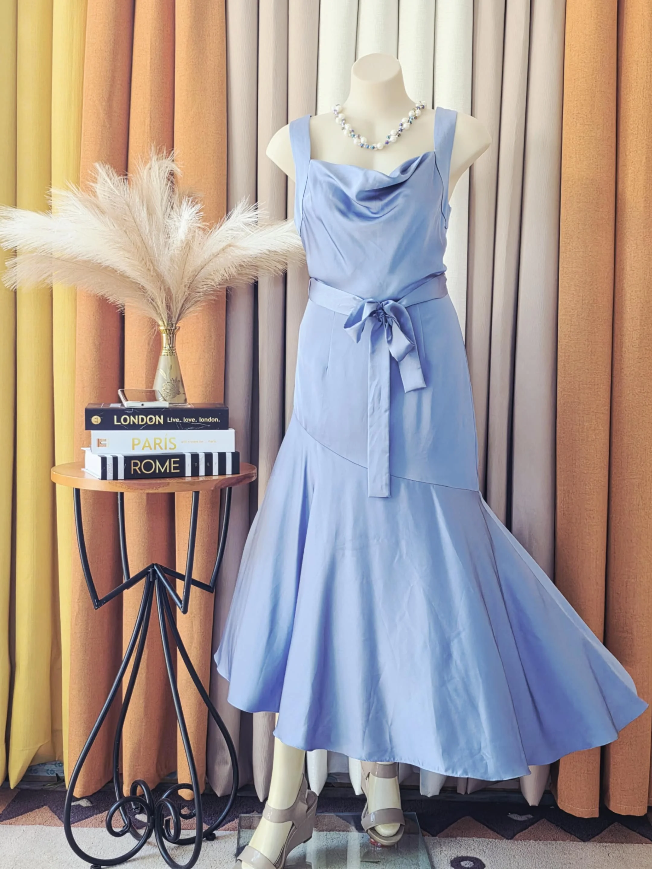 A blue dress with a pearl necklace.