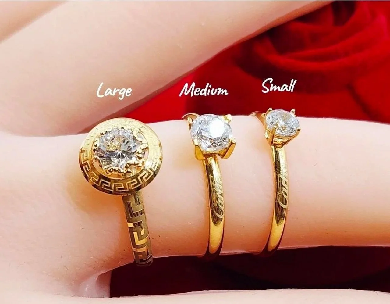 Gold rings with diamonds, labeled as large, medium, and small on a finger.