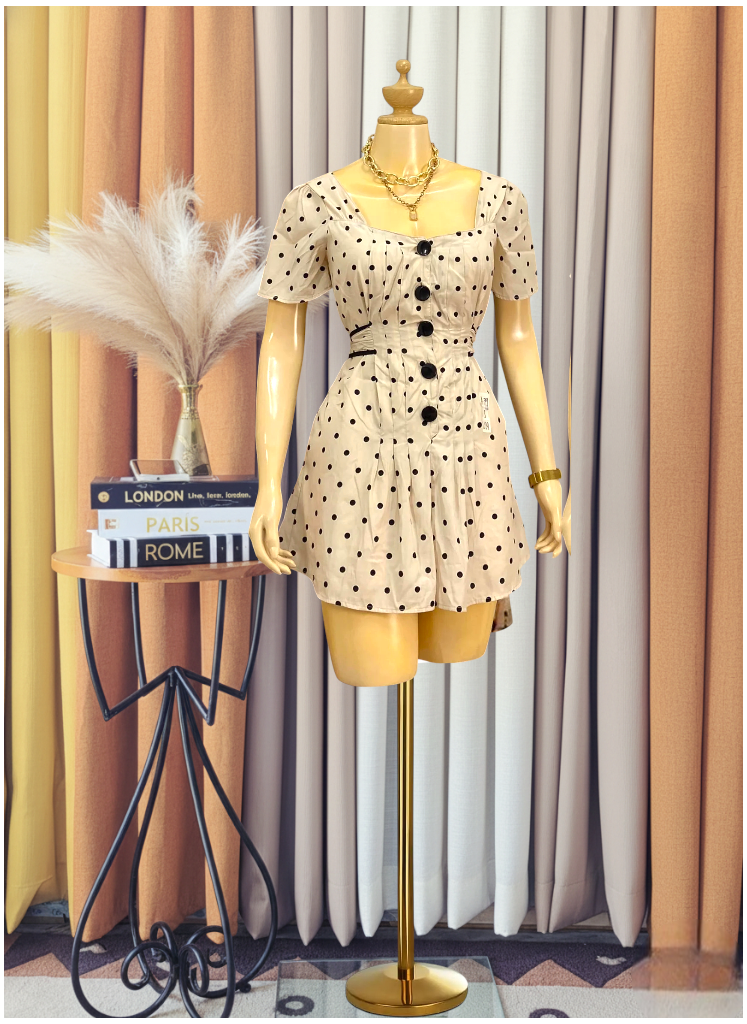 beige polka dot romper with black buttons