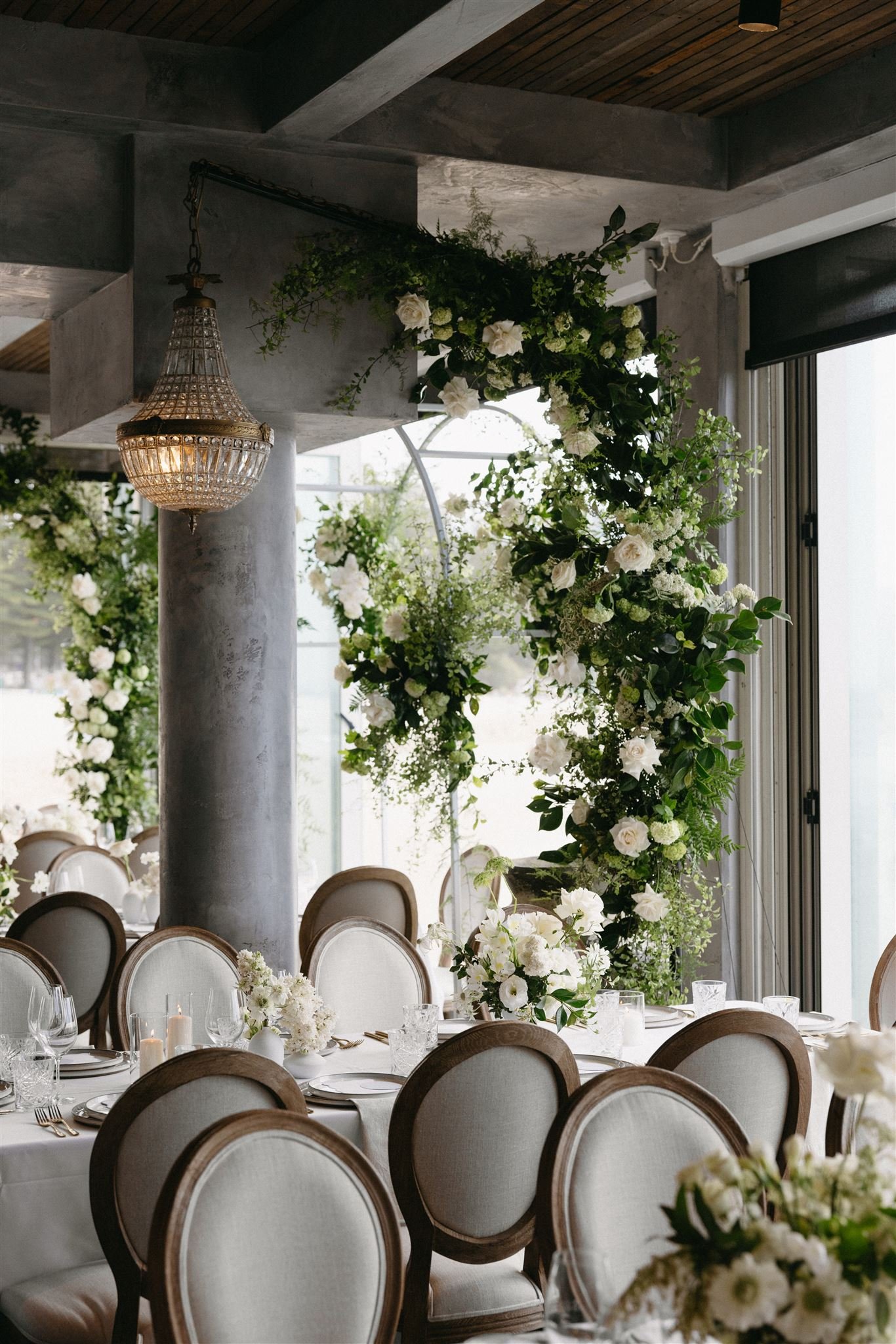 Freestanding curved poles holding lighting and florals