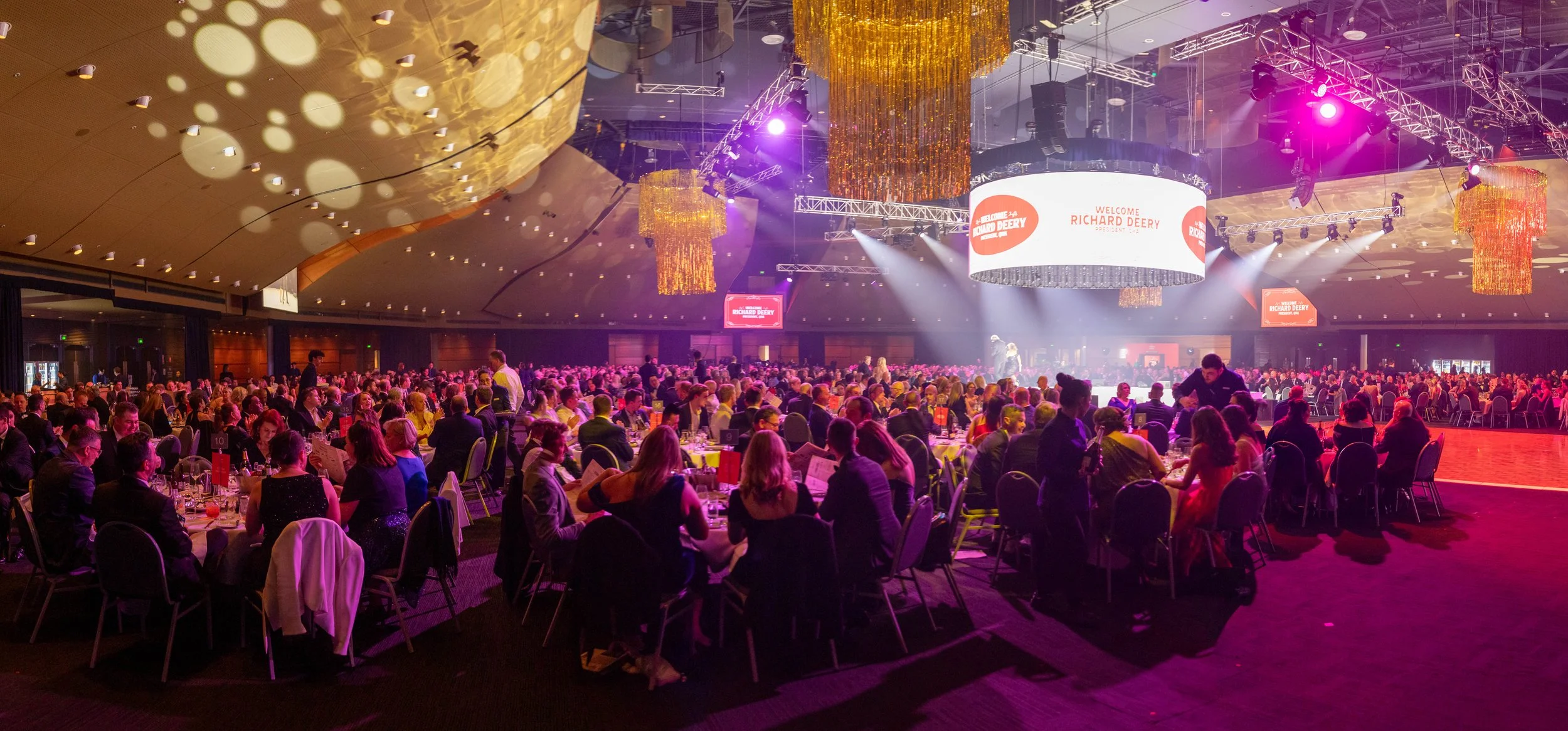 Custom-made gold tinsel hoop chandeliers installed for a large corporate event at Brisbane Convention & Exhibition Centre