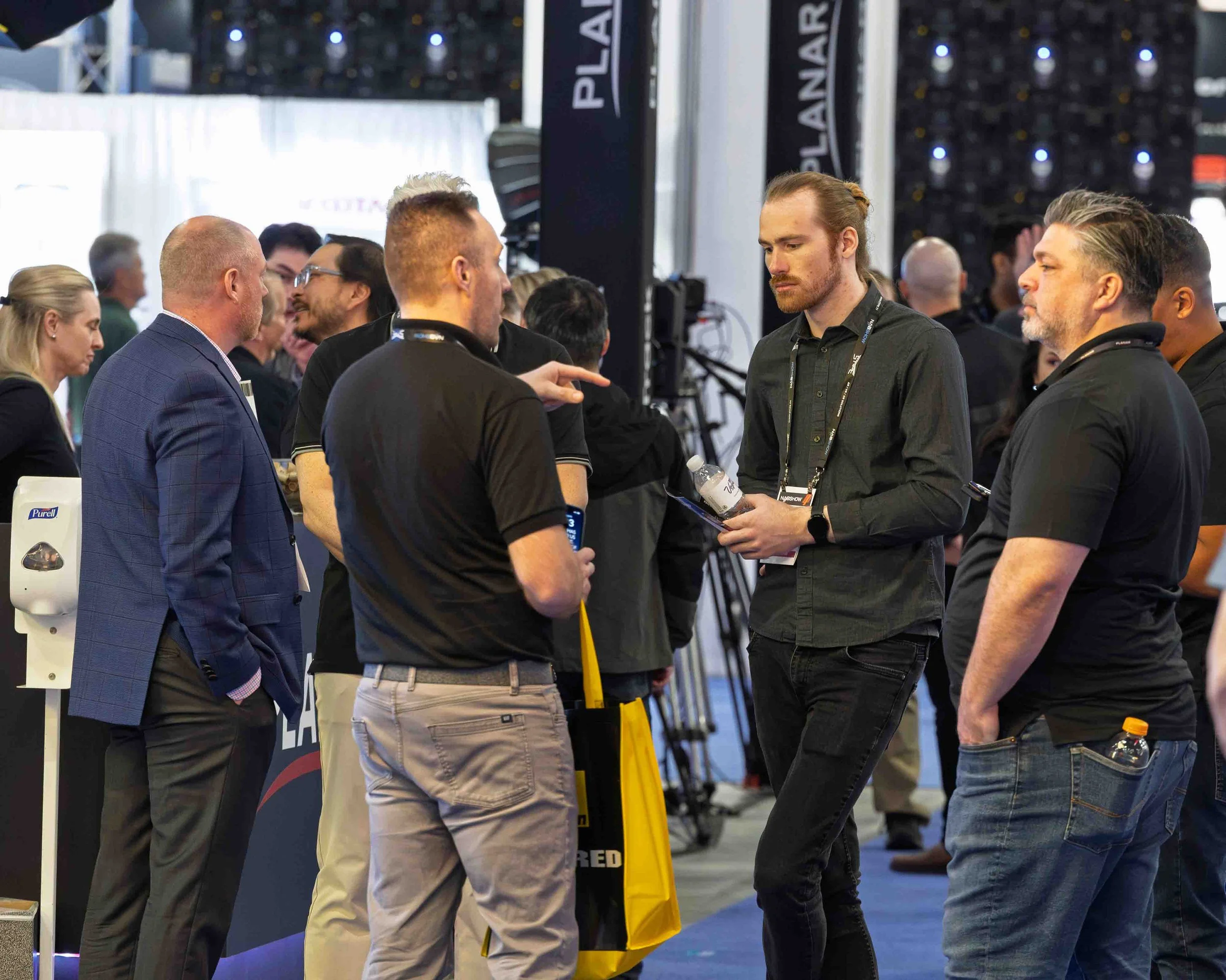 Group of men and women in conversation at a professional event or conference.