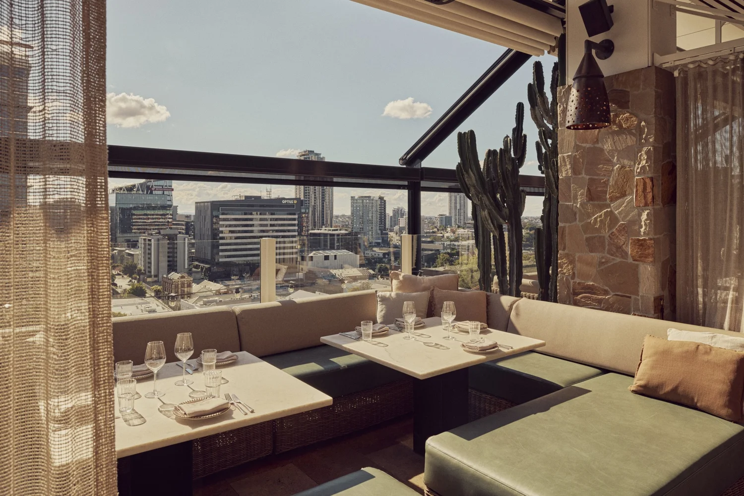 Booth seating at MAYA with green cushions and a view across Fortitude Valley