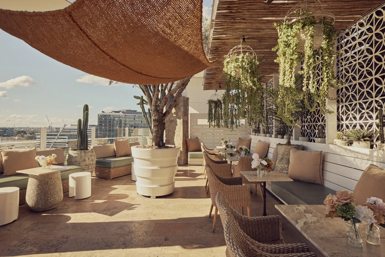 Courtyard at MAYA with wicker chairs, banquette seating and hanging plants