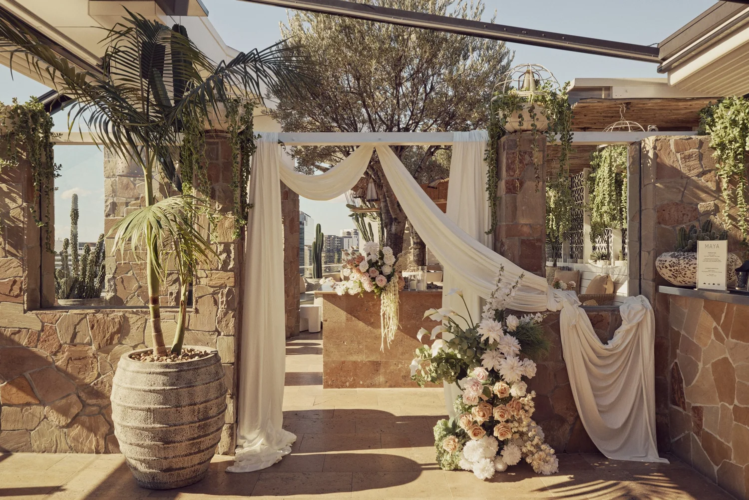 Entrance to the Patio Bar at MAYA dressed with draped fabric and a floral arrangement