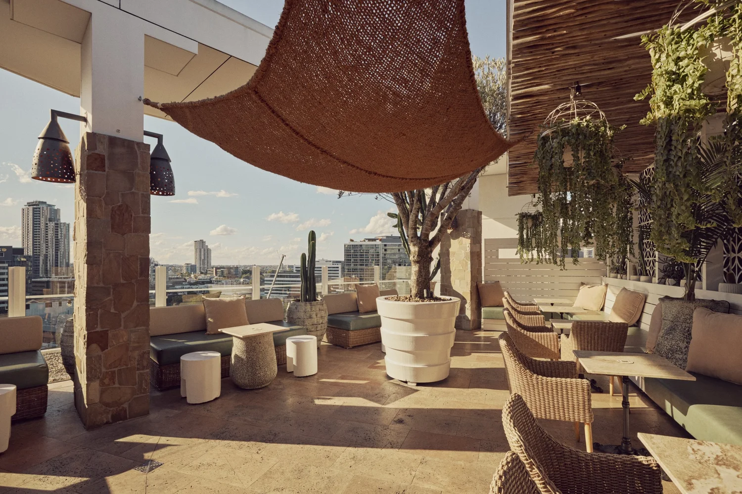 Wide view of the MAYA rooftop with stone columns and lounge seating