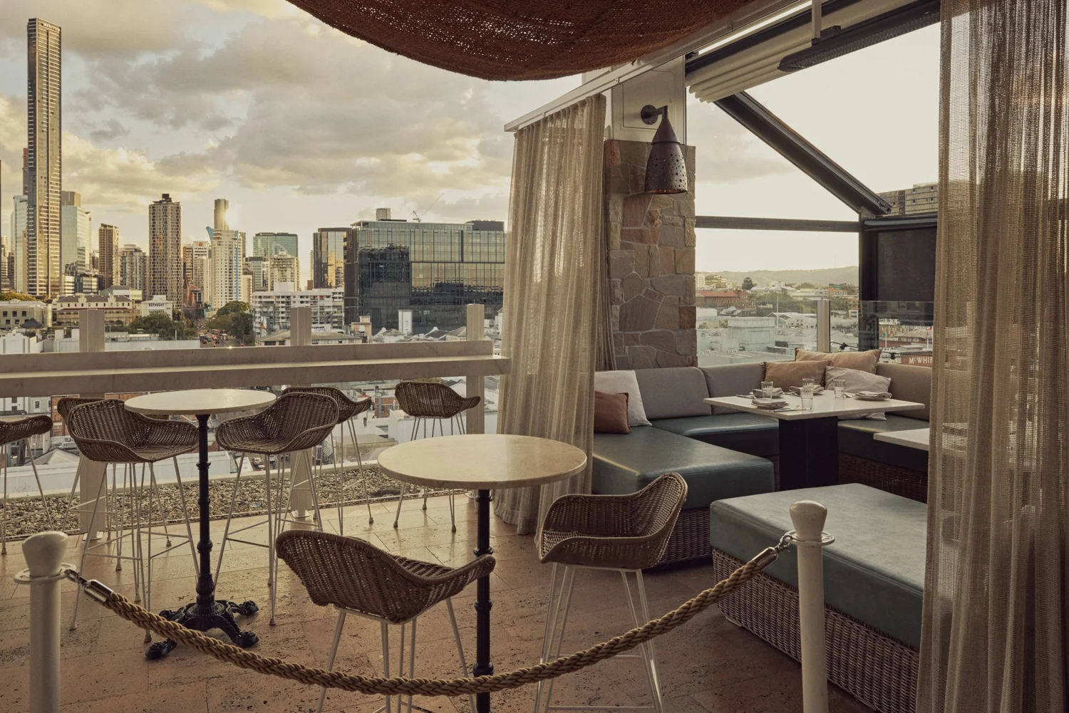 A roped-off section of the MAYA rooftop with high tables and city views