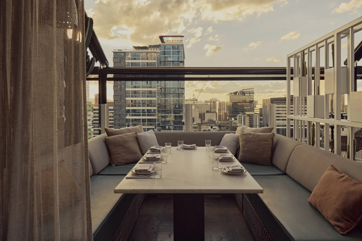 Long booth table at MAYA set for dinner at dusk