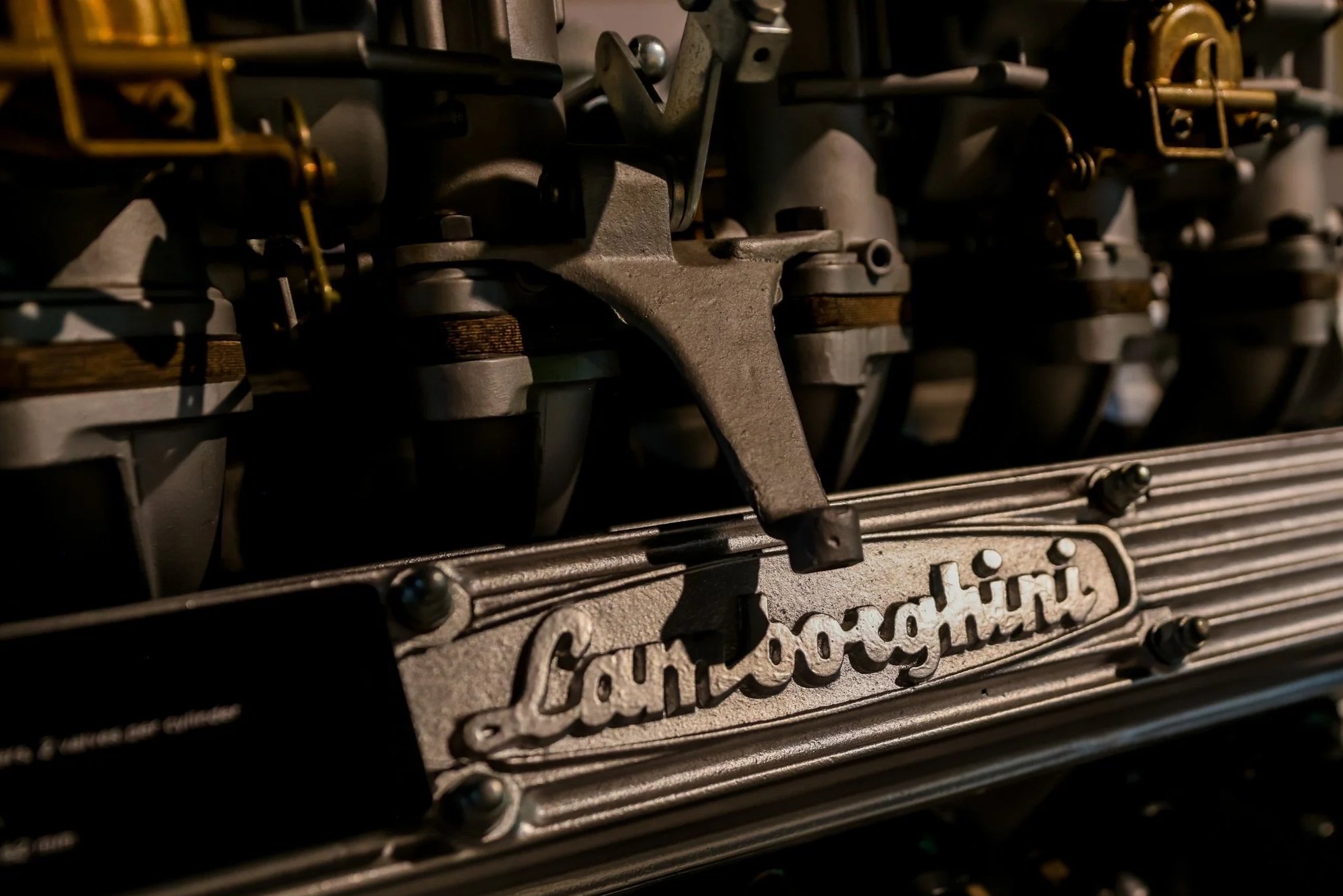 Close-up of a vintage Lamborghini engine with the Lamborghini logo visible on the metallic component.