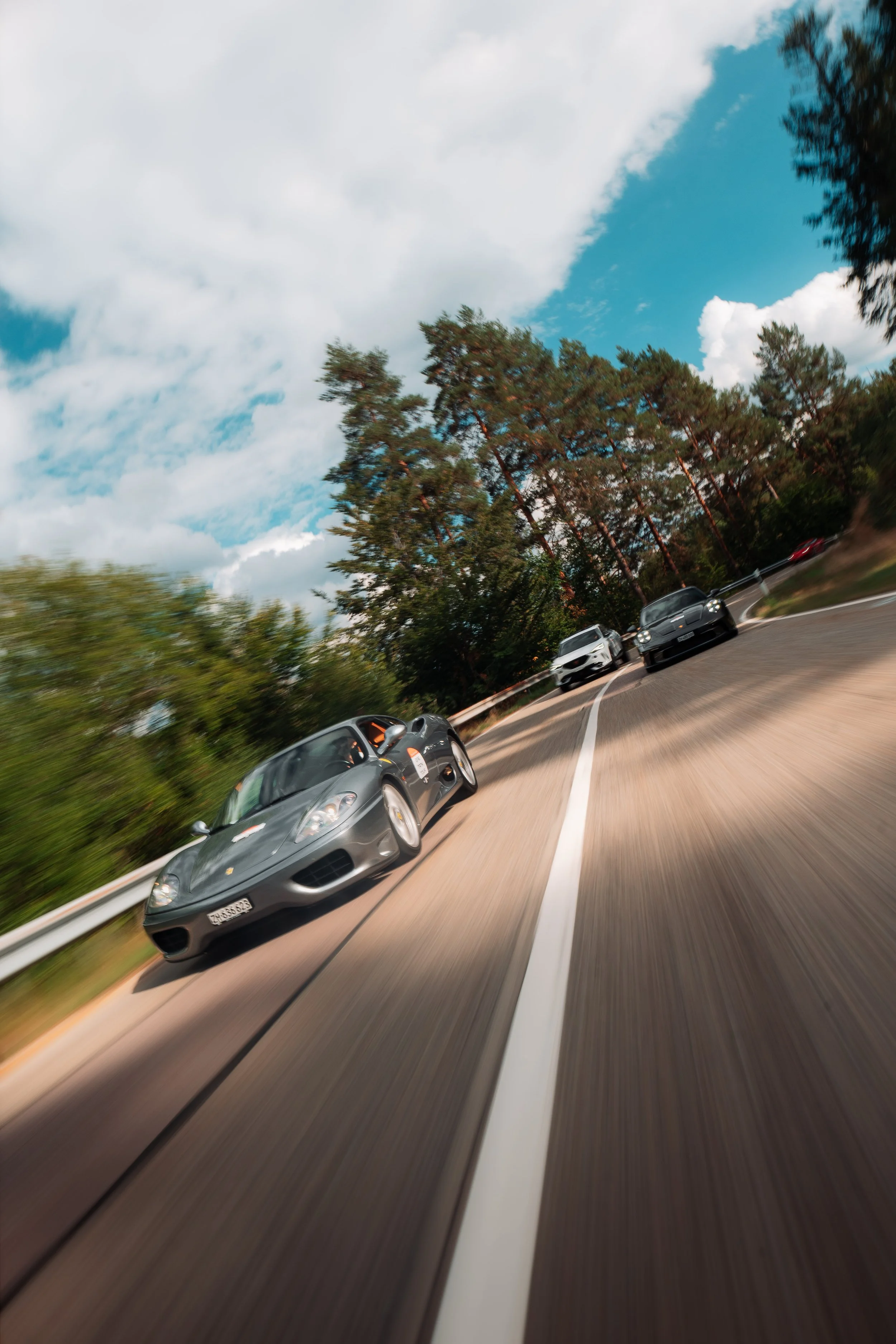 Porsche auf einer Strasse im Schwarzwald, aus dem Auto dahinter gesehen, One Tank Tour Schwarzwald 2026