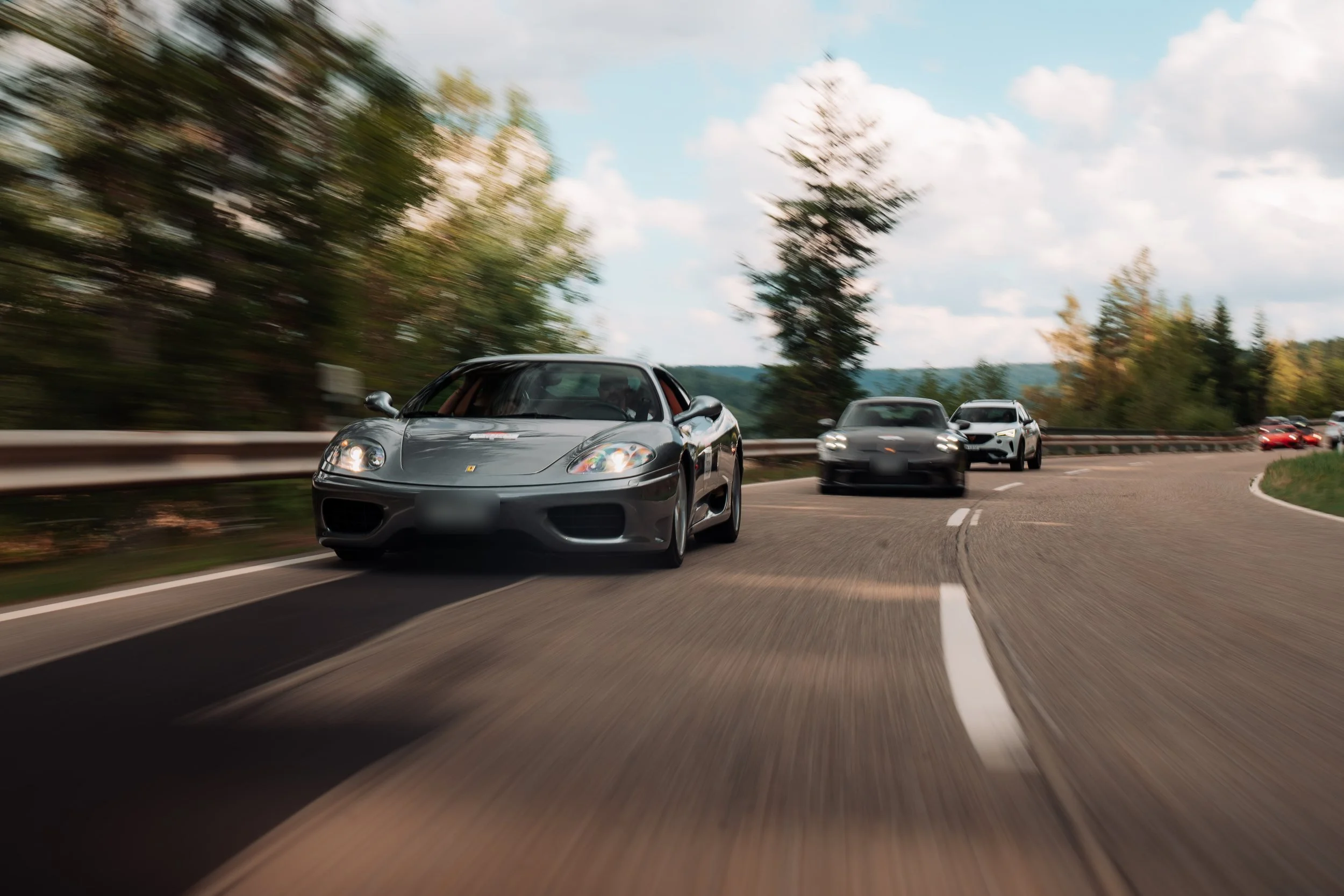Grey Ferrari 360 leading the convoy on an open road during a previous One Tank Tour
