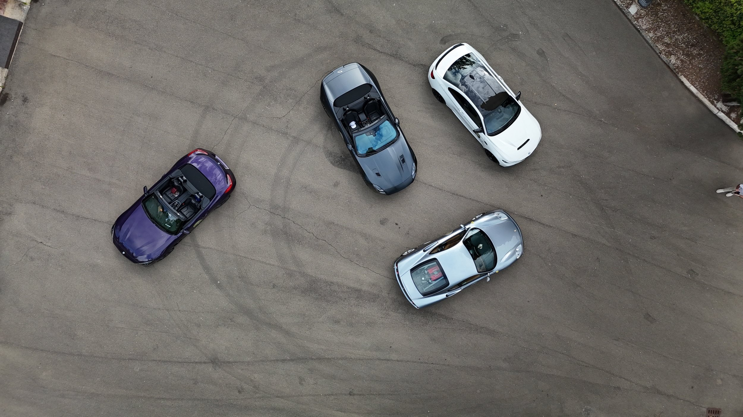 Four sports cars parked together, seen from above, at a stop on a previous One Tank Tour