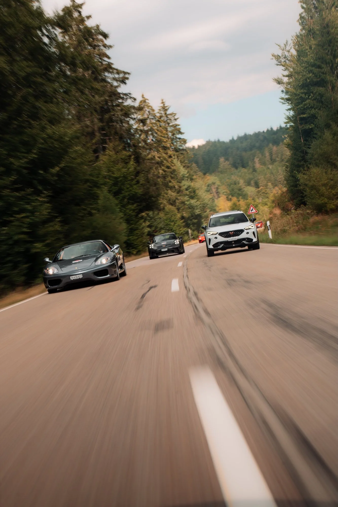 Grey Ferrari 360 leading the convoy on an open road during a previous One Tank Tour