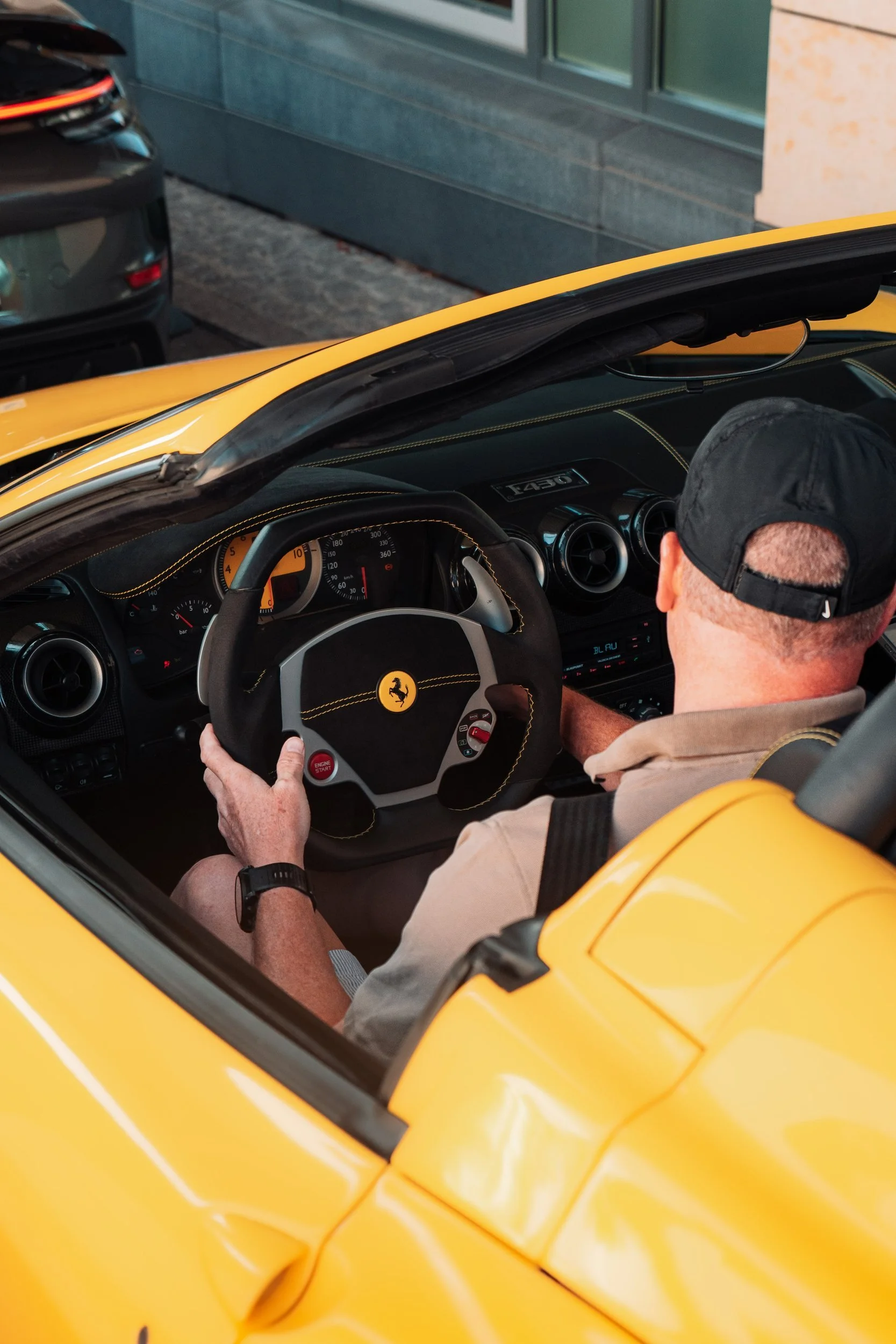 Fahrer am Steuer eines gelben Ferrari Spider mit offenem Verdeck auf einer One Tank Tour