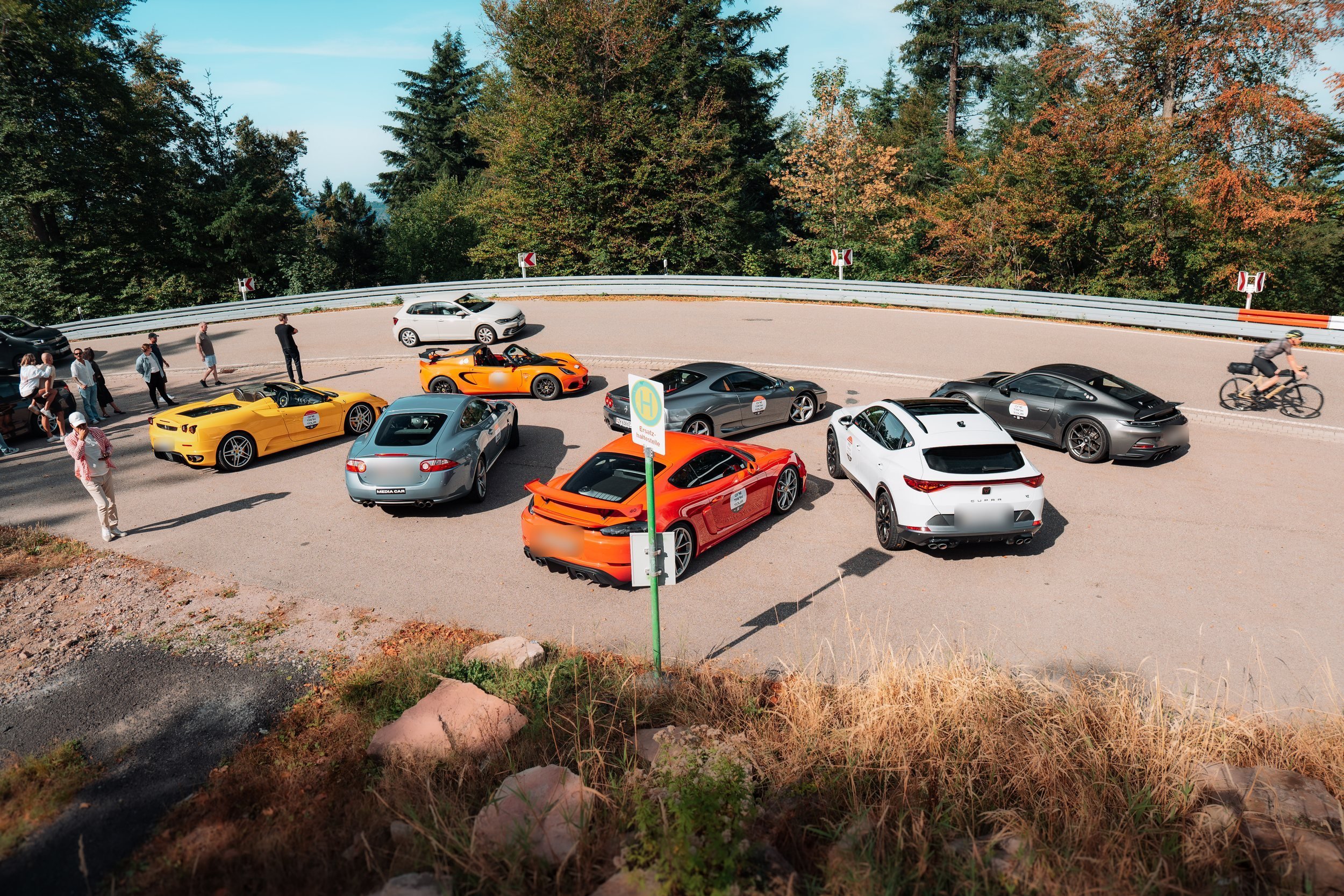 Sports cars gathered at a mountain stop on a previous One Tank Tour