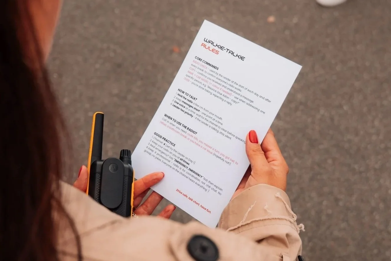 Teilnehmer mit dem gedruckten Roadbook und einem Funkgerät vor dem Start einer One Tank Tour