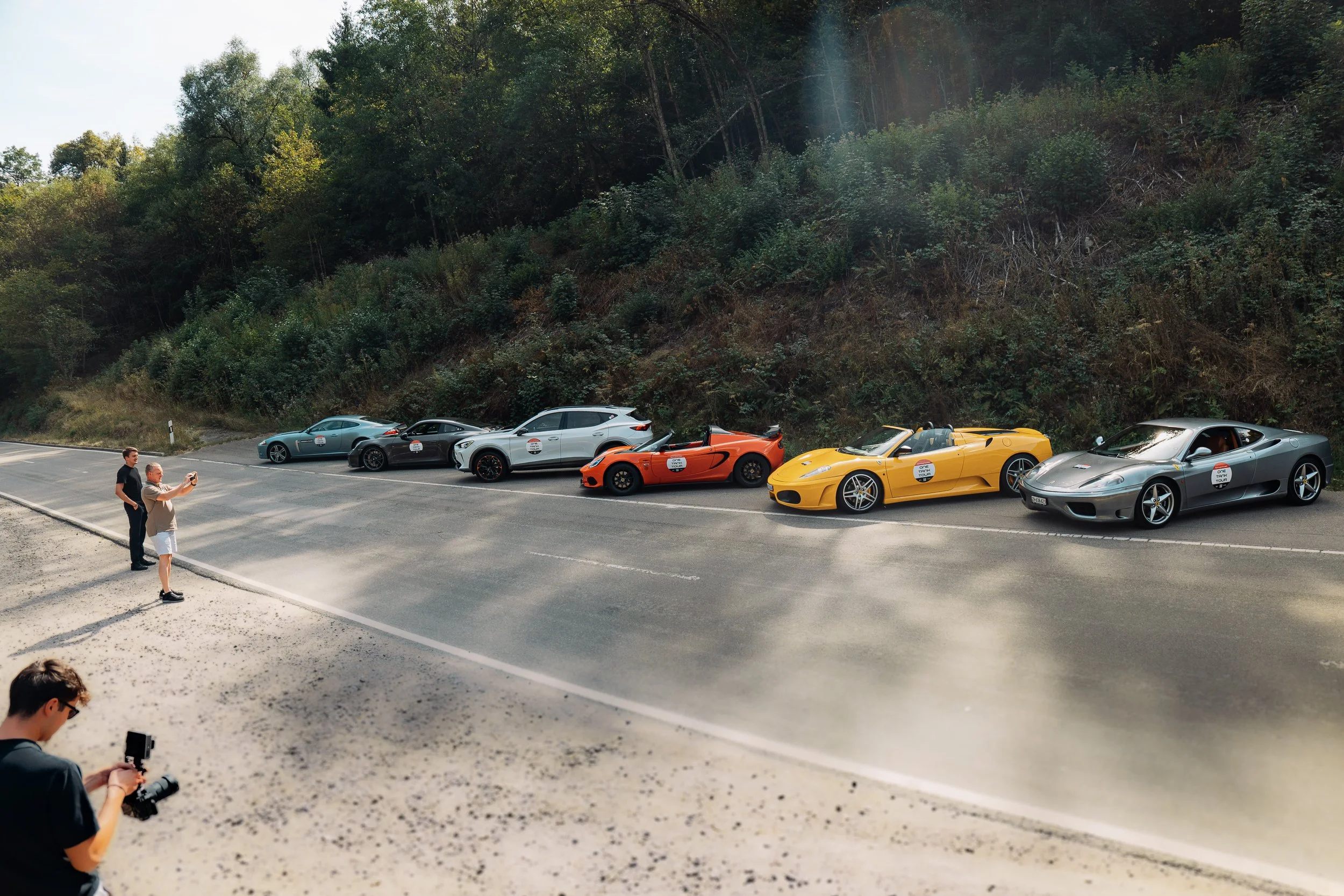 Ferrari, Lotus, Cupra und Porsche am Strassenrand während einer Pause der One Tank Tour