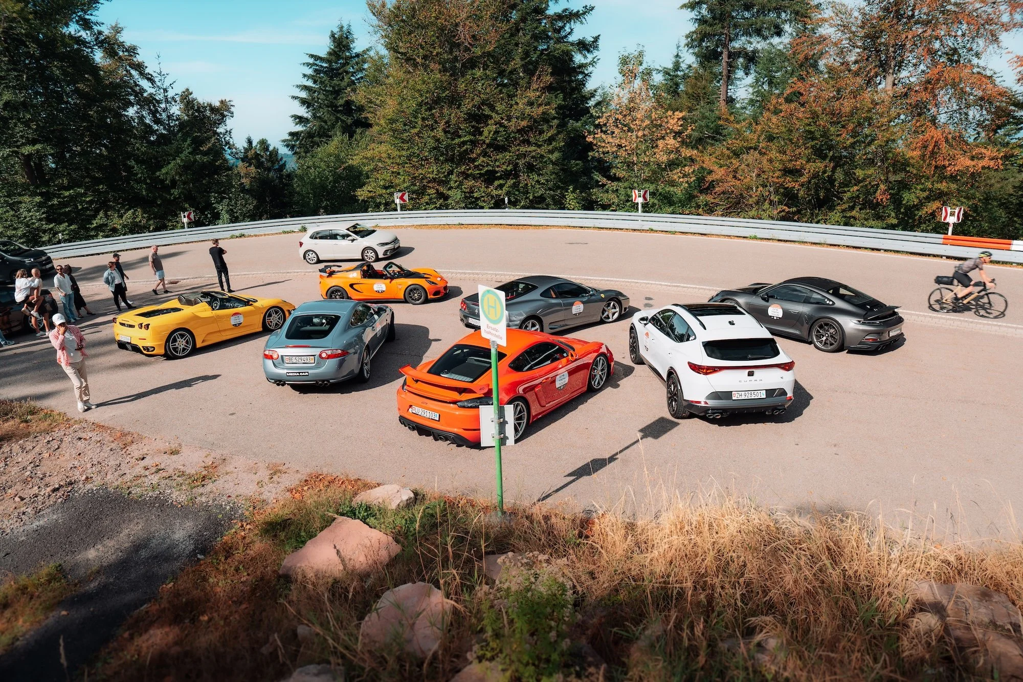 Sports cars gathered at a mountain stop on a previous One Tank Tour
