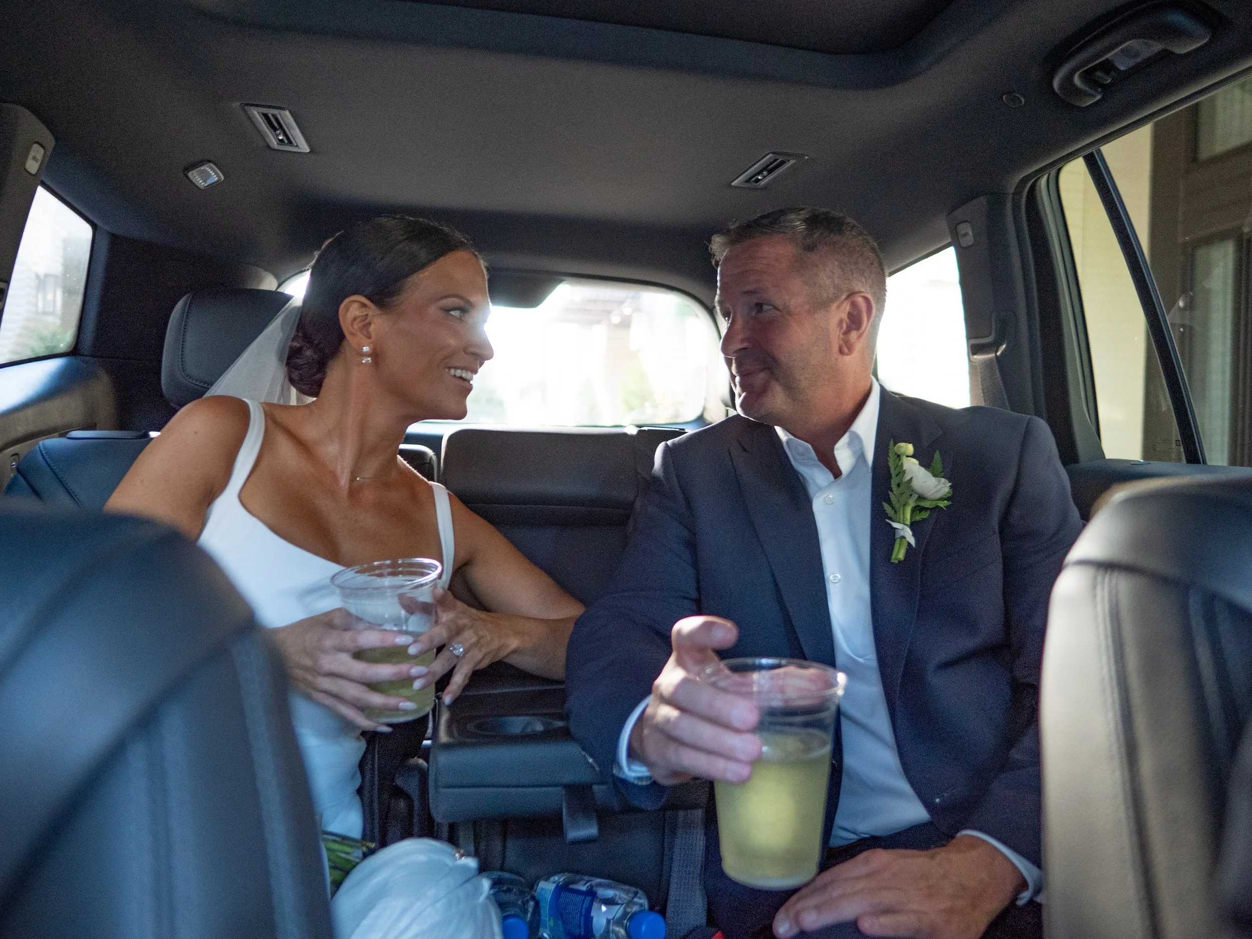 Bride and groom relaxing together inside a private black SUV in Savannah