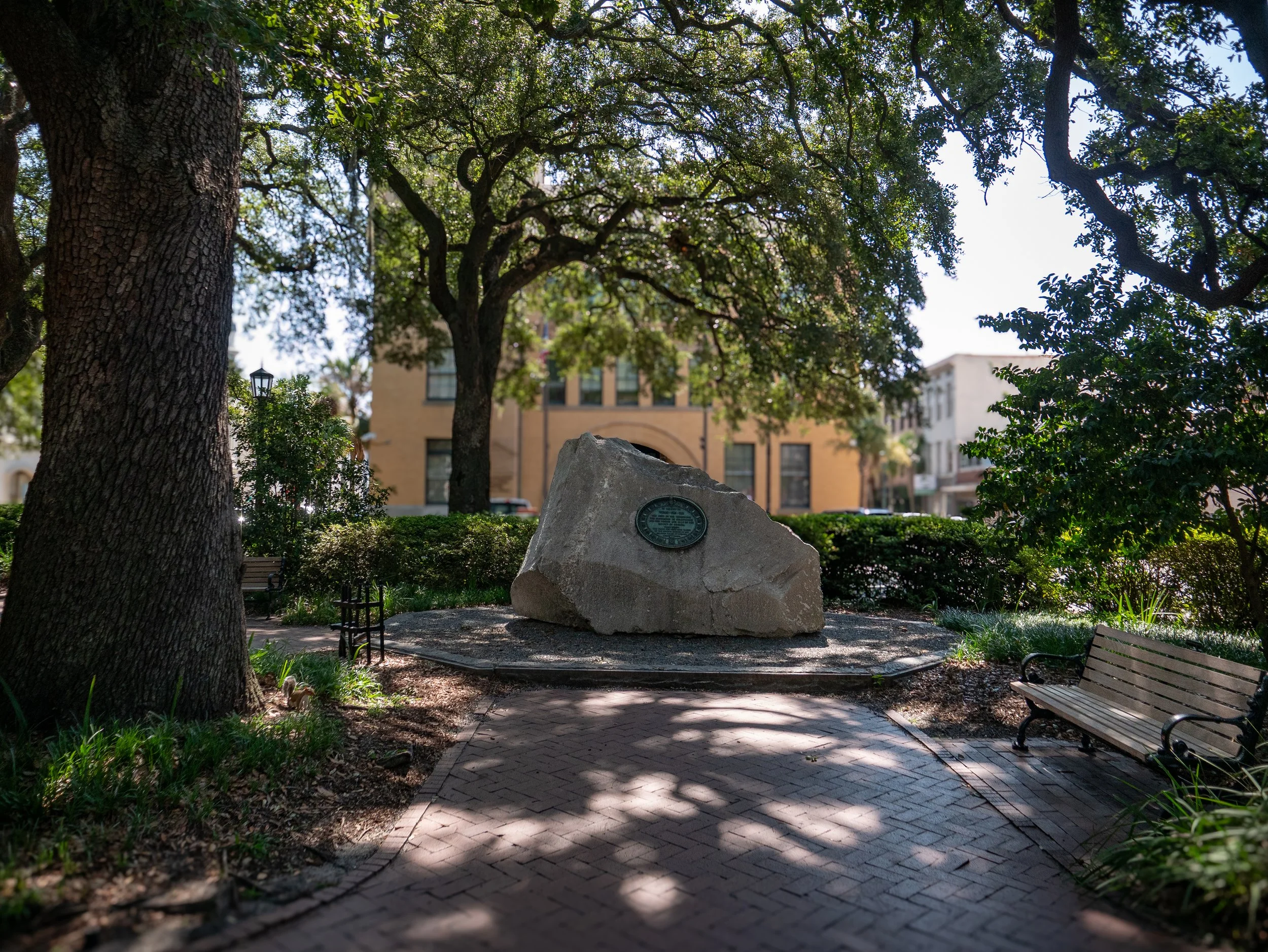 Tomochichi memorial boulder beneath live oak trees in Wright Square