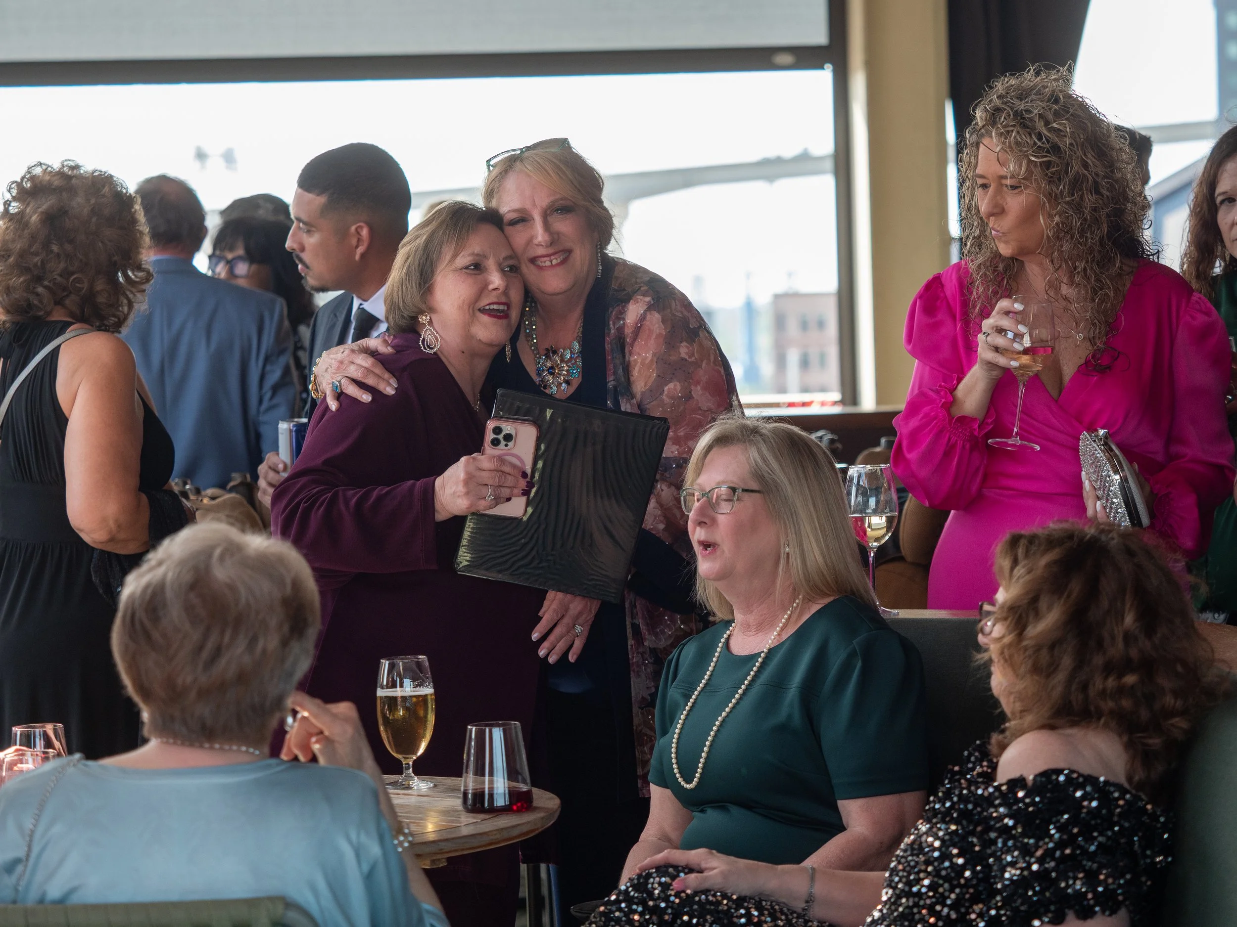 Corporate event attendees greet one another with a hug during cocktail hour at The Lost Square rooftop bar in Savannah.