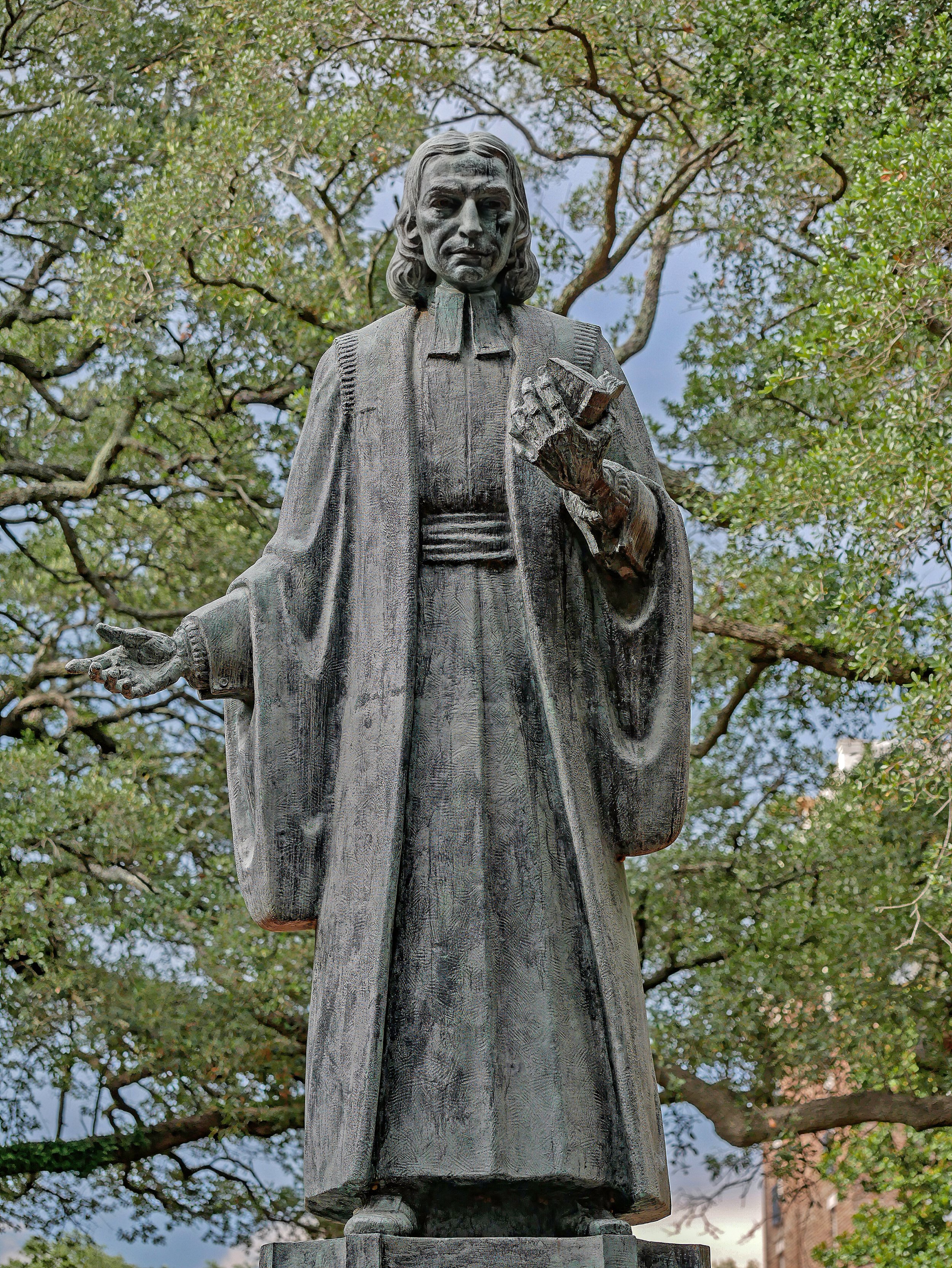 John Wesley Memorial statue in Reynolds Square, Savannah, Georgia, honoring the founder of Methodism beneath the canopy of historic live oaks.