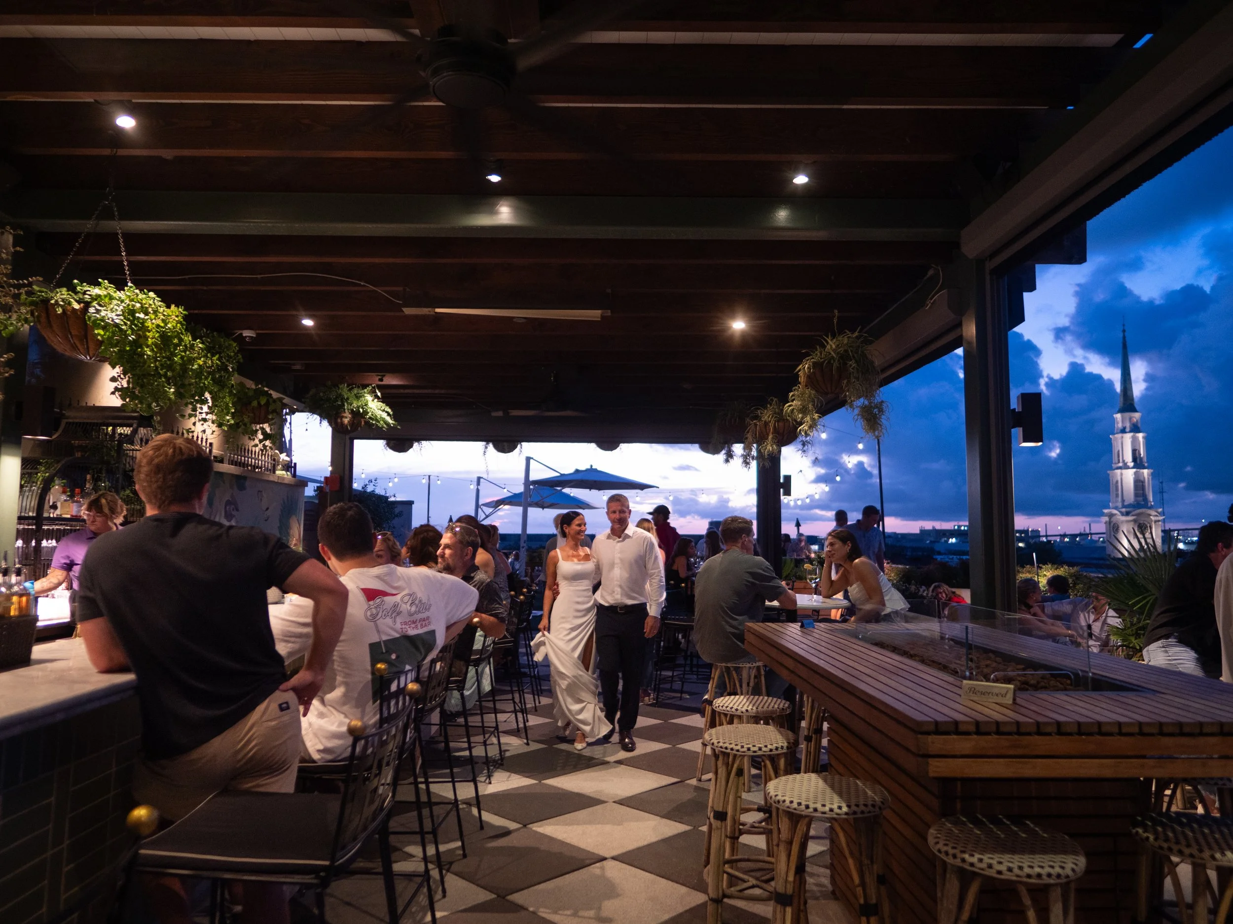 Bride and groom walking together through the Peregrin rooftop during blue hour