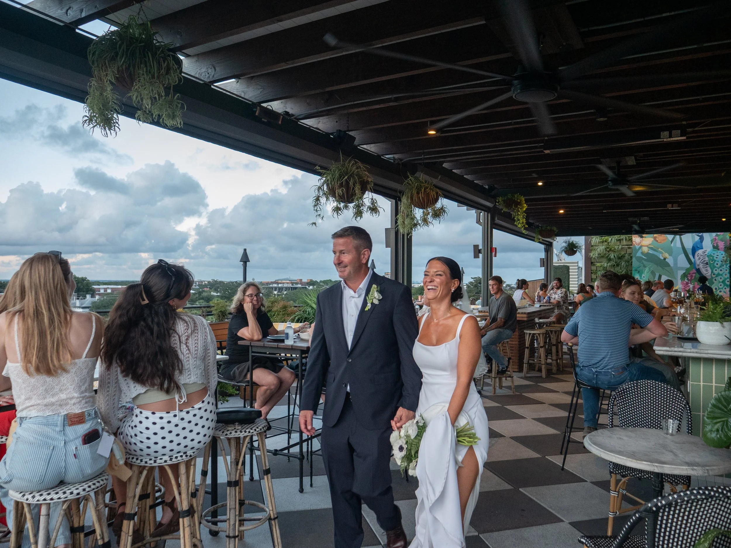 Bride and groom walking through the lively Peregrin rooftop at Perry Lane Hotel