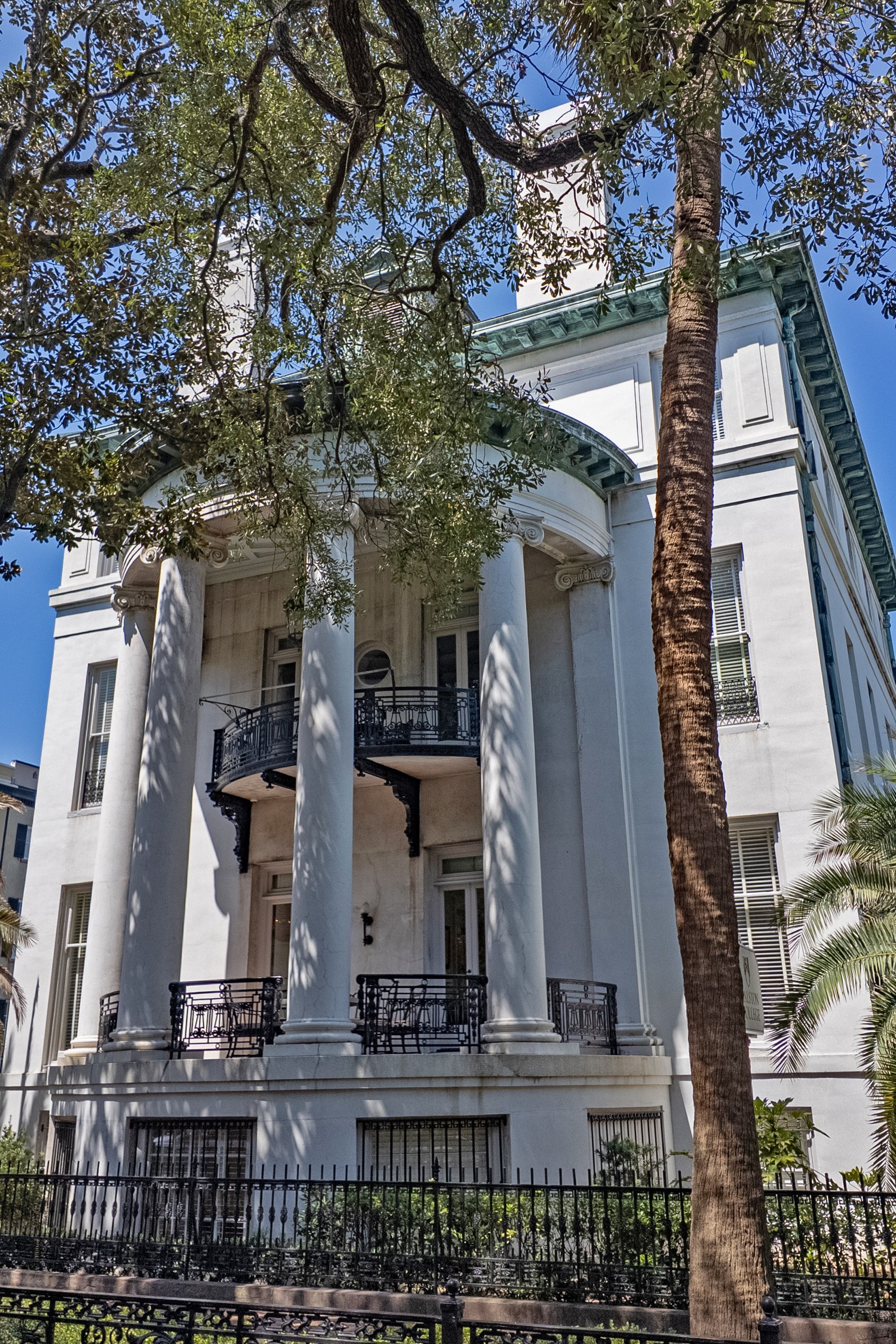 Philbrick-Eastman House exterior with tall columns, a curved portico, and ornate iron balconies.