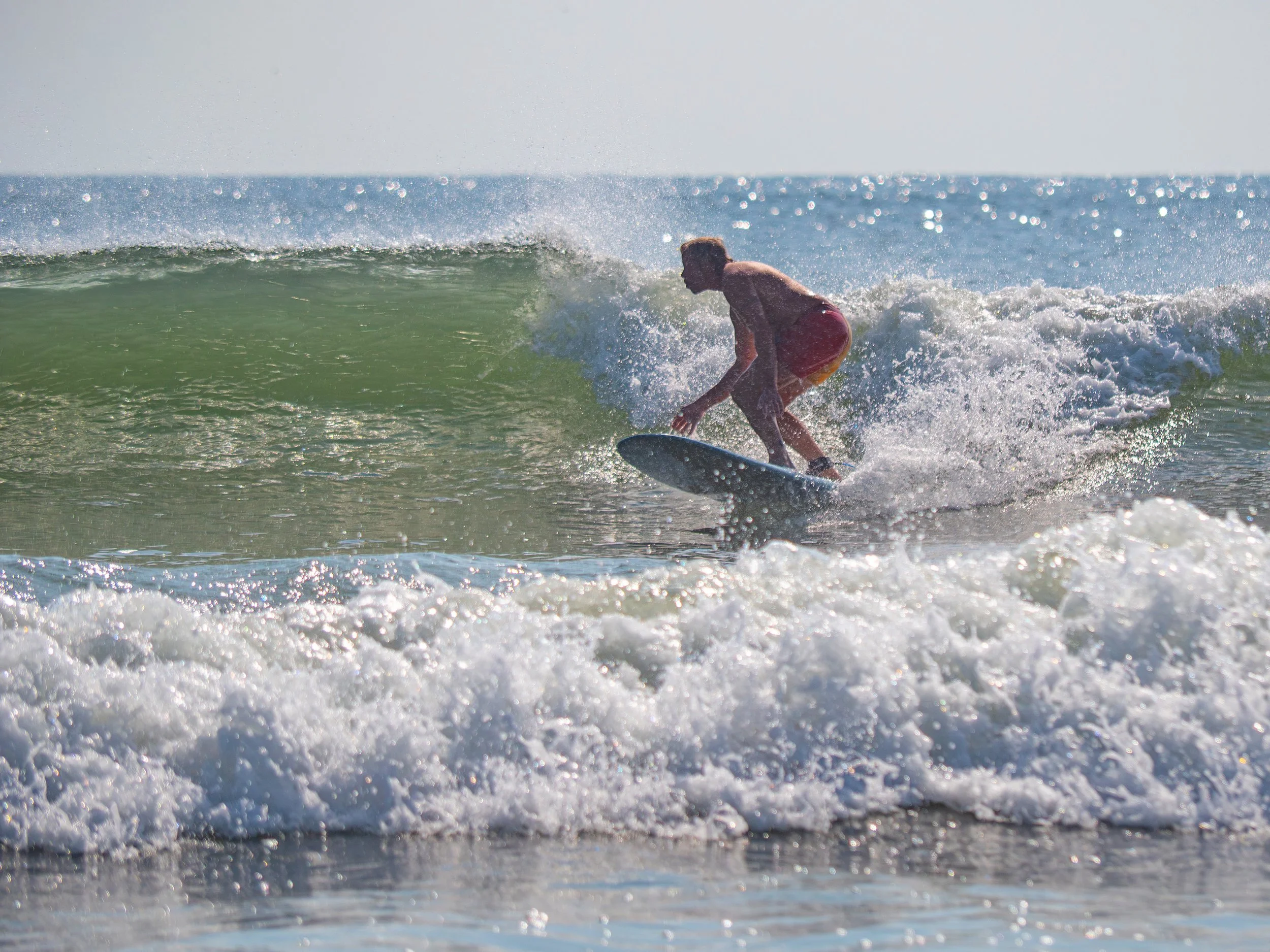 Surfer riding waves along the beach at Tybee Island near Savannah Georgia