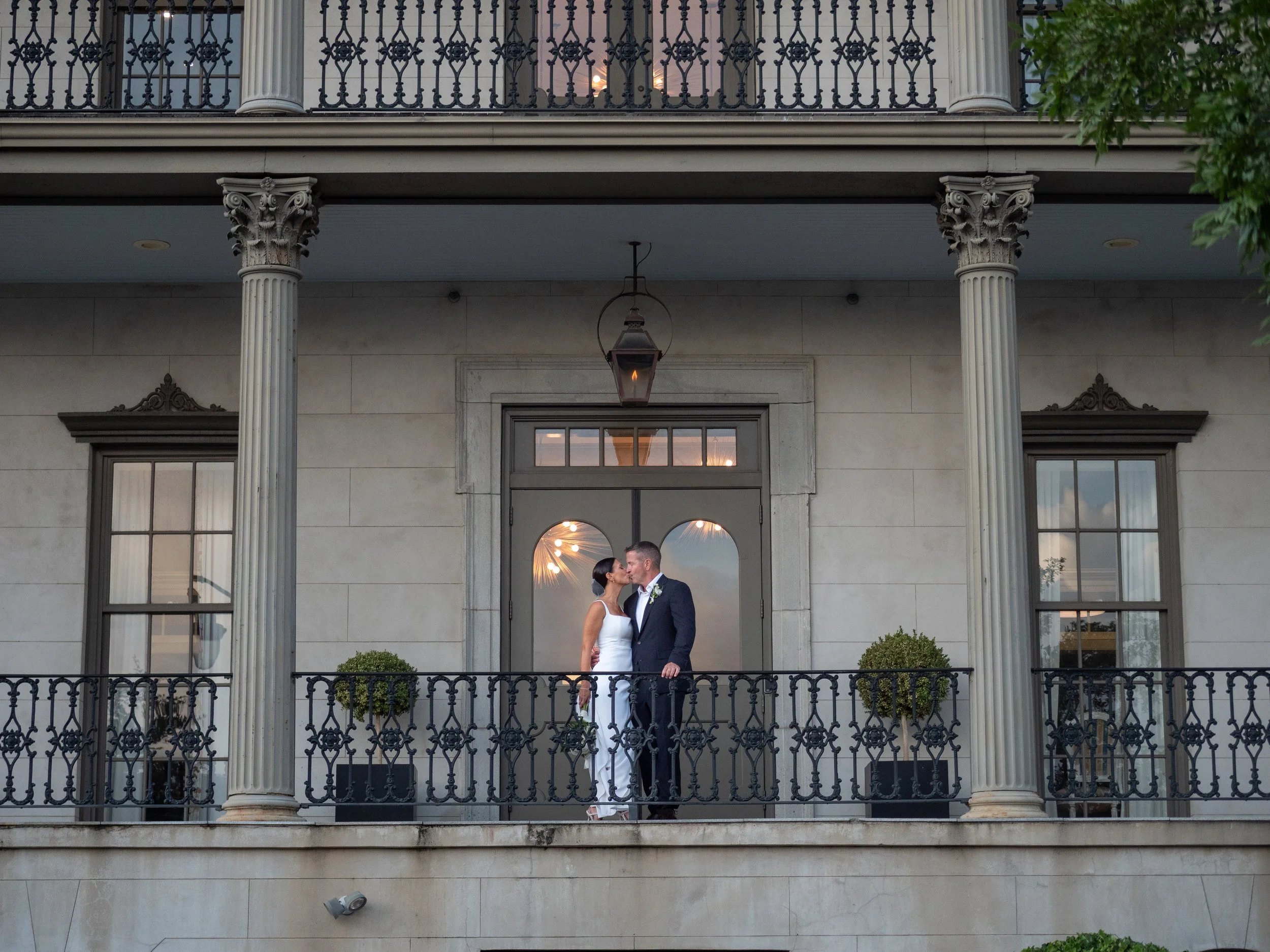 Bride and groom kissing on the balcony of a historic Savannah mansion