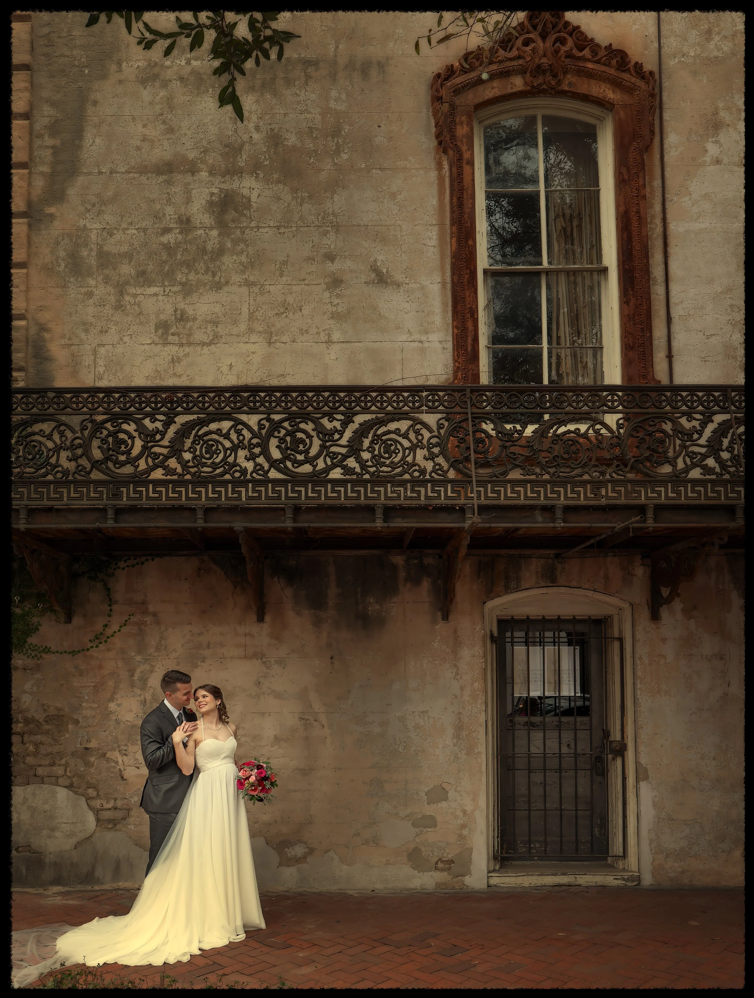 Bride and groom share a romantic wedding moment surrounded by the historic architecture of downtown Savannah during an elegant wedding portrait session in the Historic District.