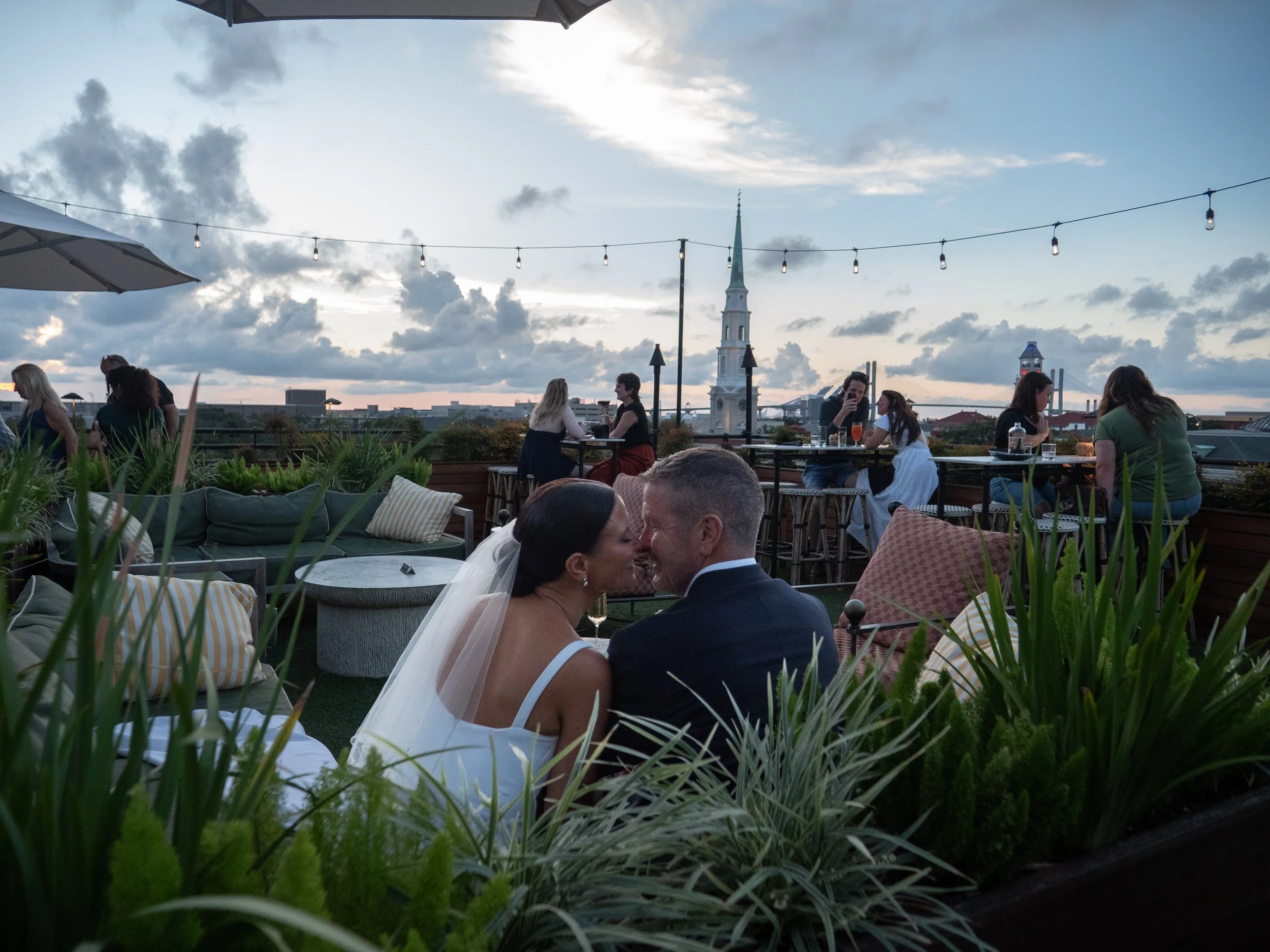 Newlyweds sharing an intimate moment on the Peregrin rooftop overlooking the Savannah skyline