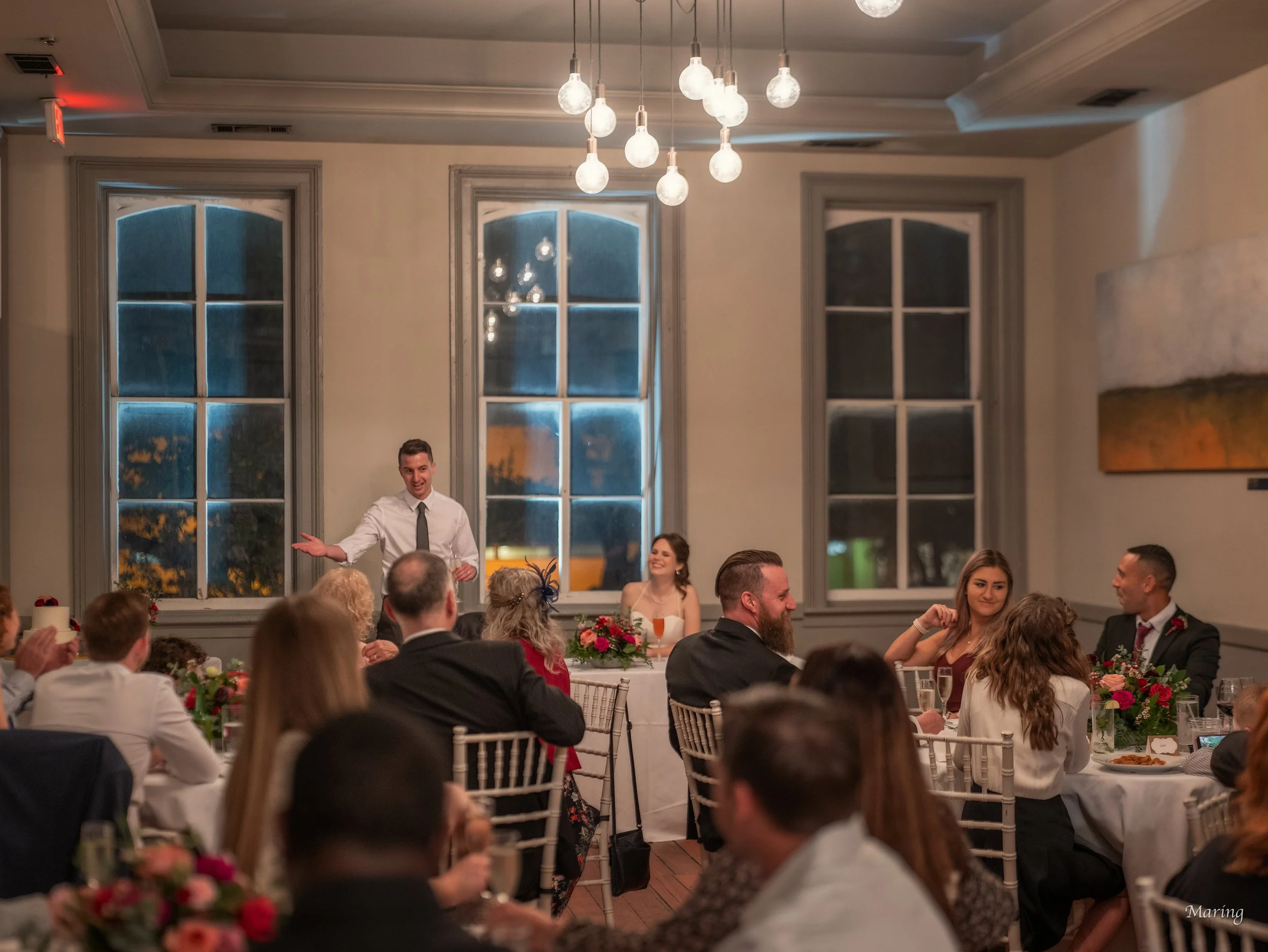 Tim raises a toast to Daniella as family and friends look on during their intimate rooftop reception at Churchill’s in Savannah.