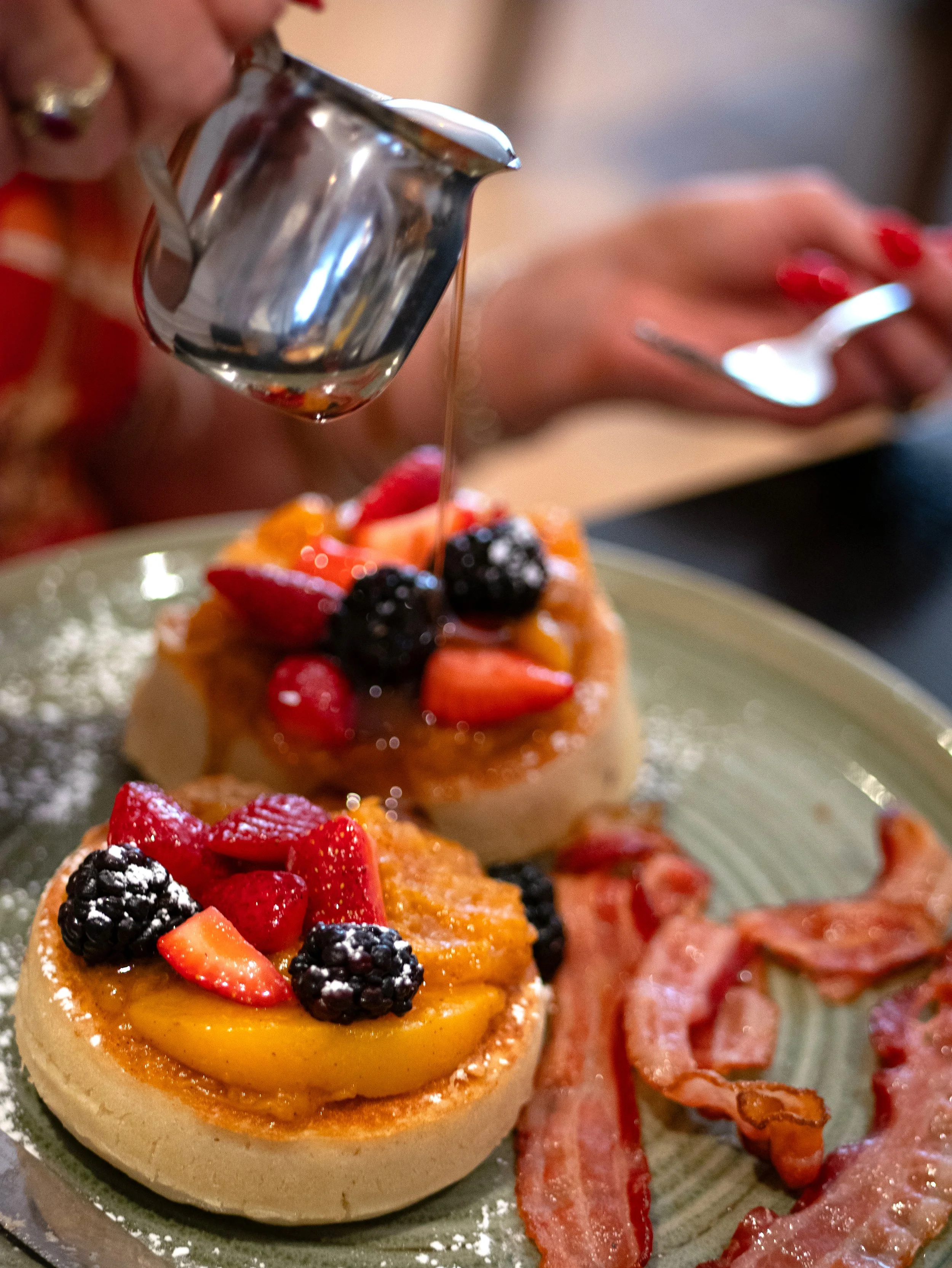 Thick pancakes topped with bourbon peaches and fresh berries at Pacci Italian Kitchen in Savannah.