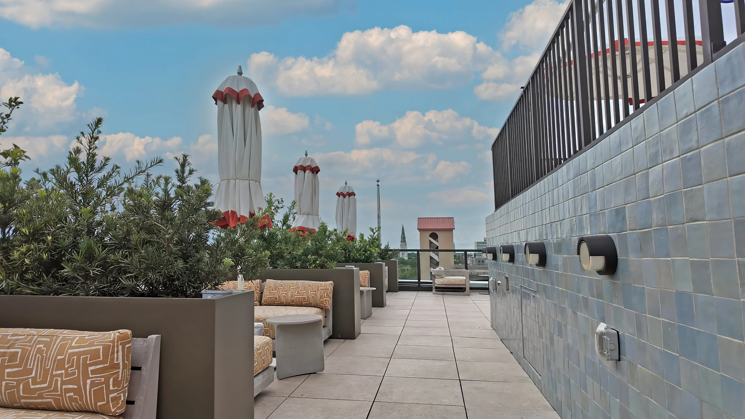 Outdoor rooftop lounge seating area at The Sun Club at Municipal Grand featuring greenery and contemporary design