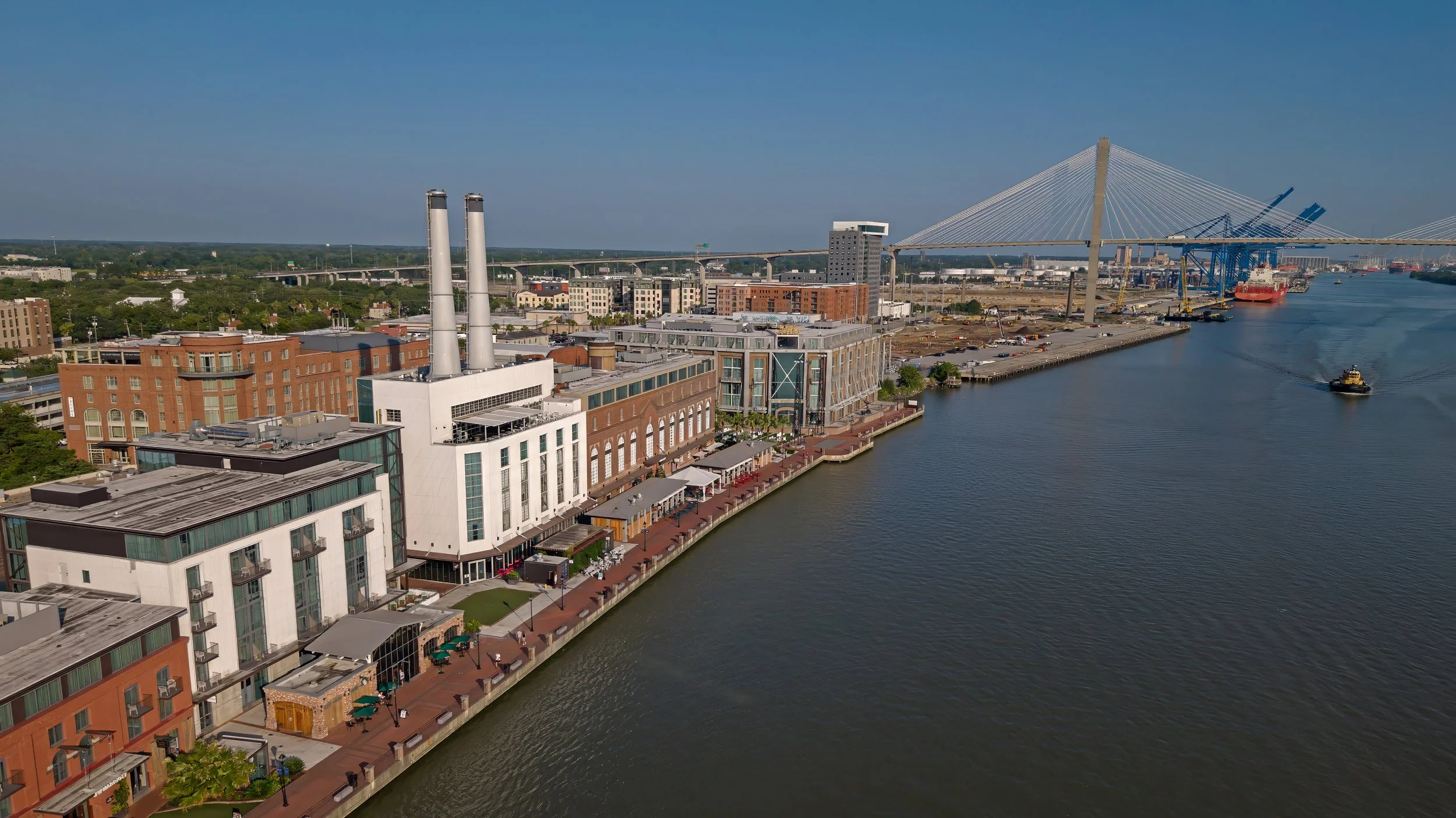 Aerial view of Plant Riverside District along the Savannah River on the morning of Fourth of July weekend before crowds arrive to celebrate America's 250th birthday in Savannah, Georgia.