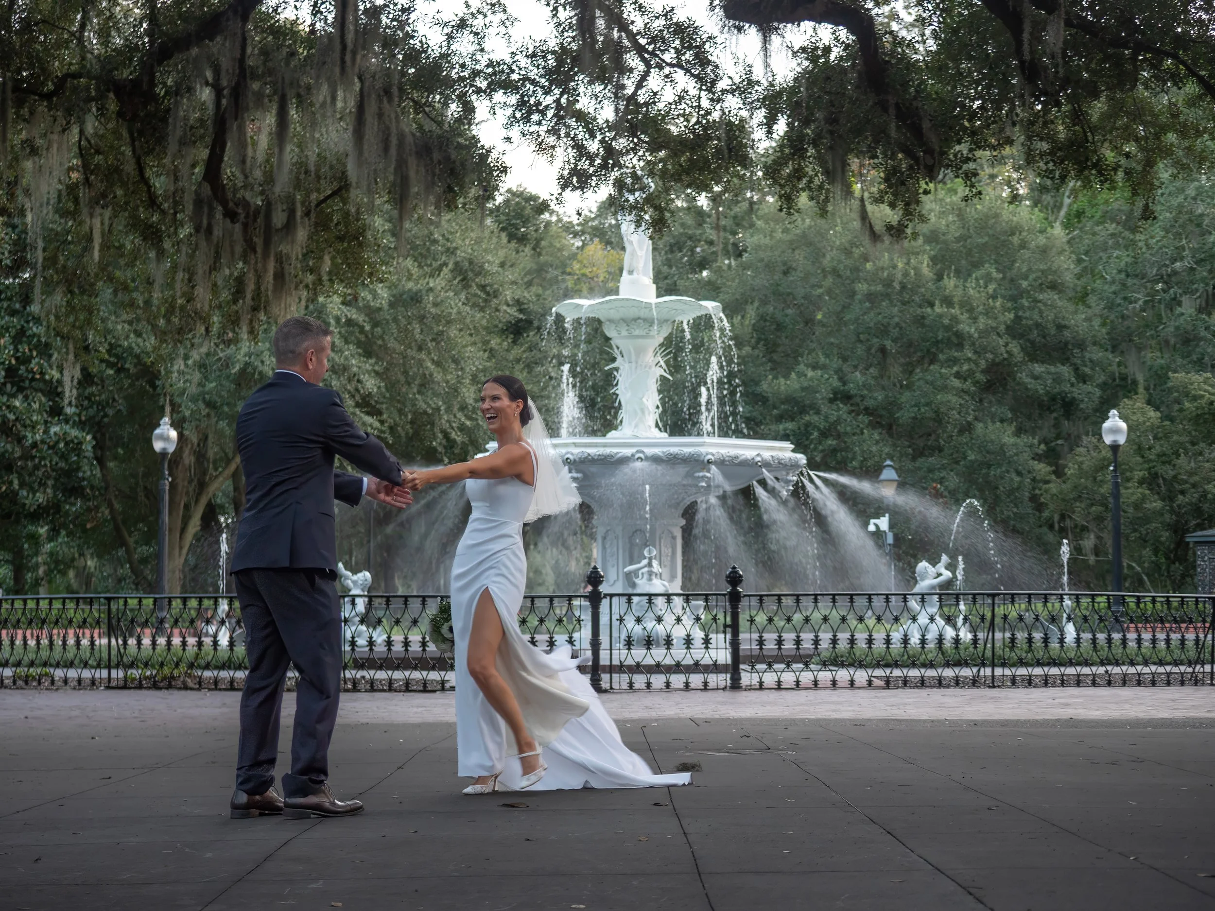 Groom twirling the bride in front of Forsyth Park Fountain