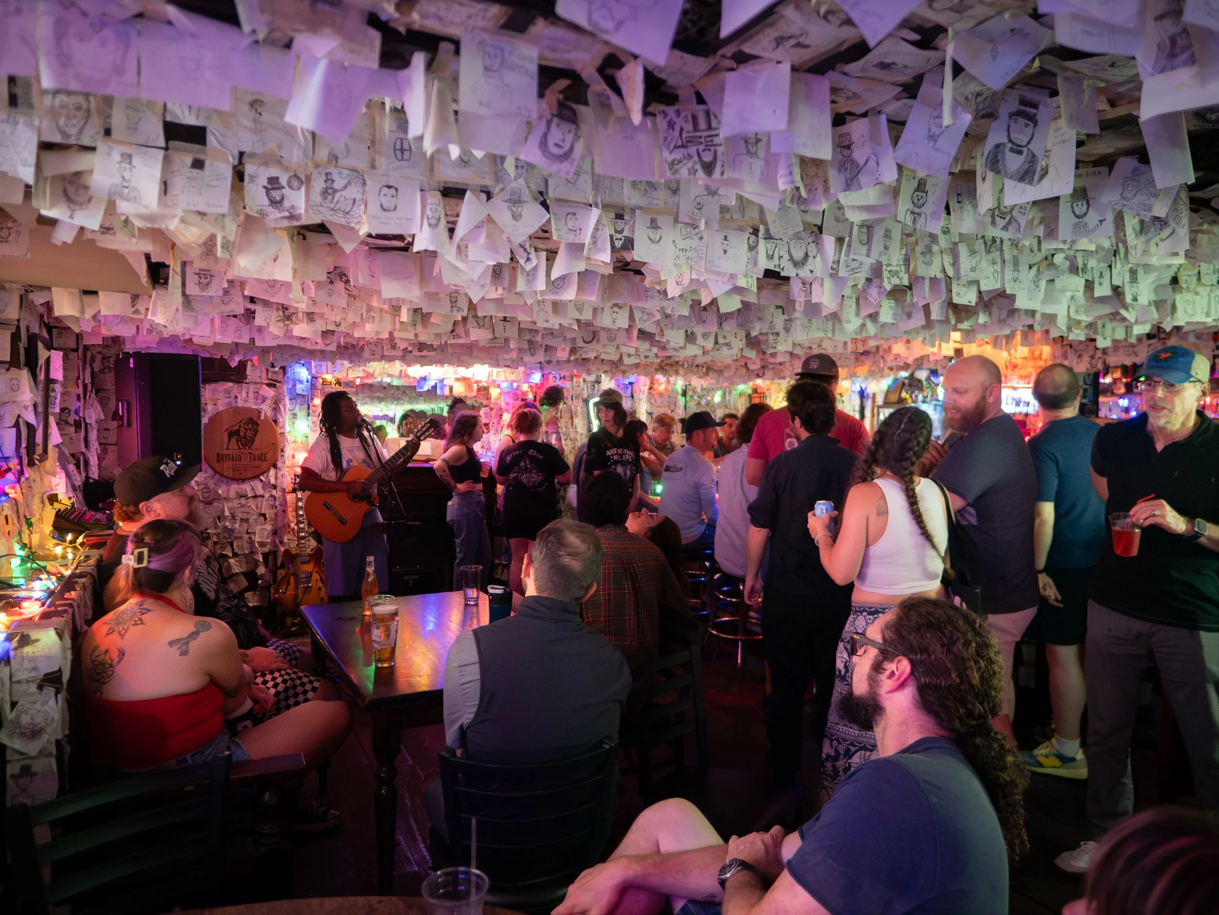 Musicians and guests gather beneath Lincoln drawings during Monday open mic at Abe’s on Lincoln