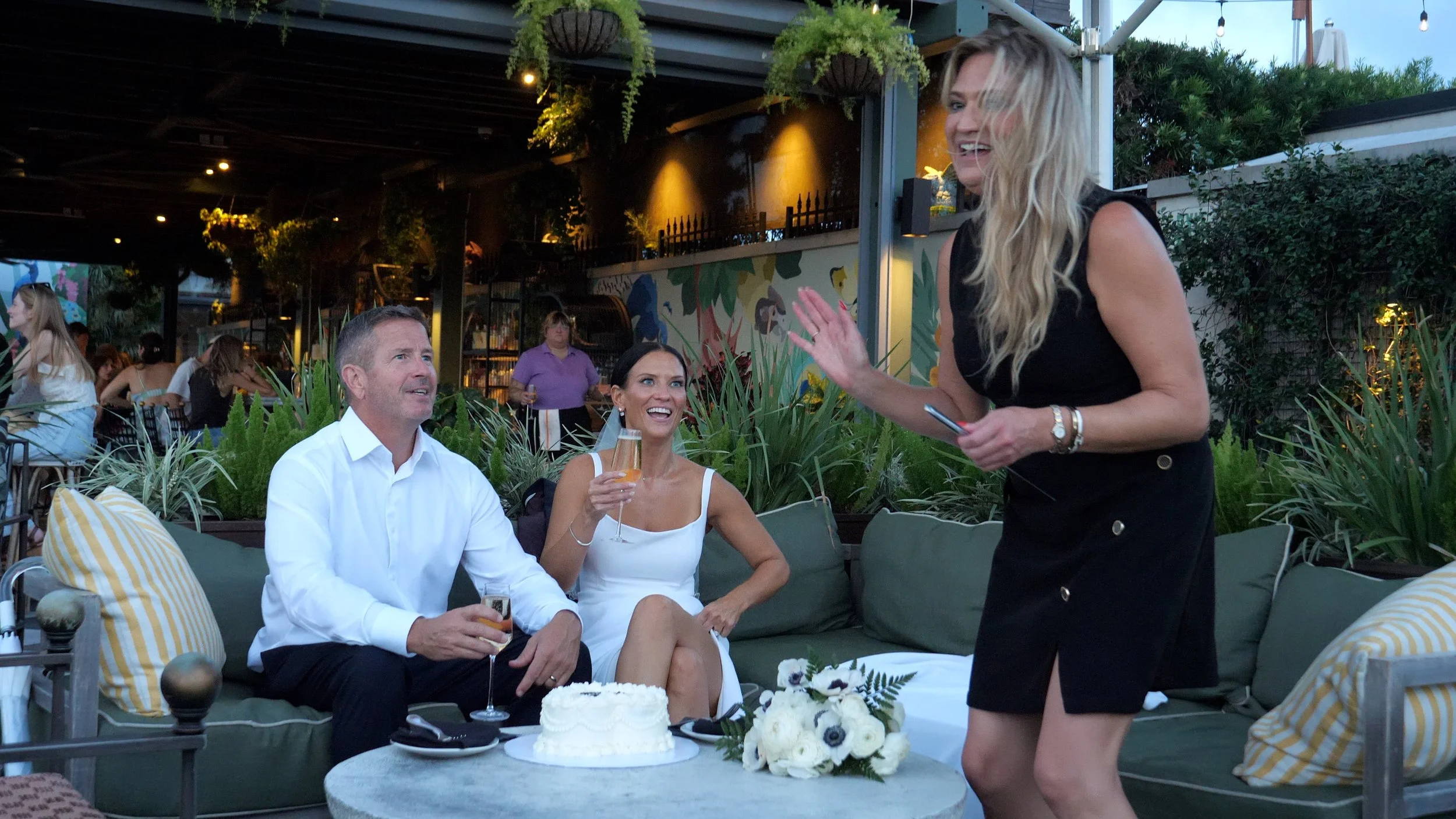 Jennifer Maring joyfully assisting an elopement couple during their rooftop celebration in Savannah.