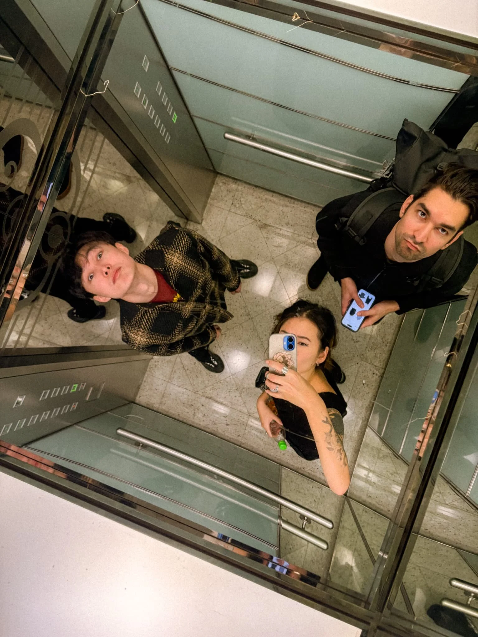 Group of friends taking a mirror selfie in the high-speed elevator at Taipei 101 in Taipei, Taiwan