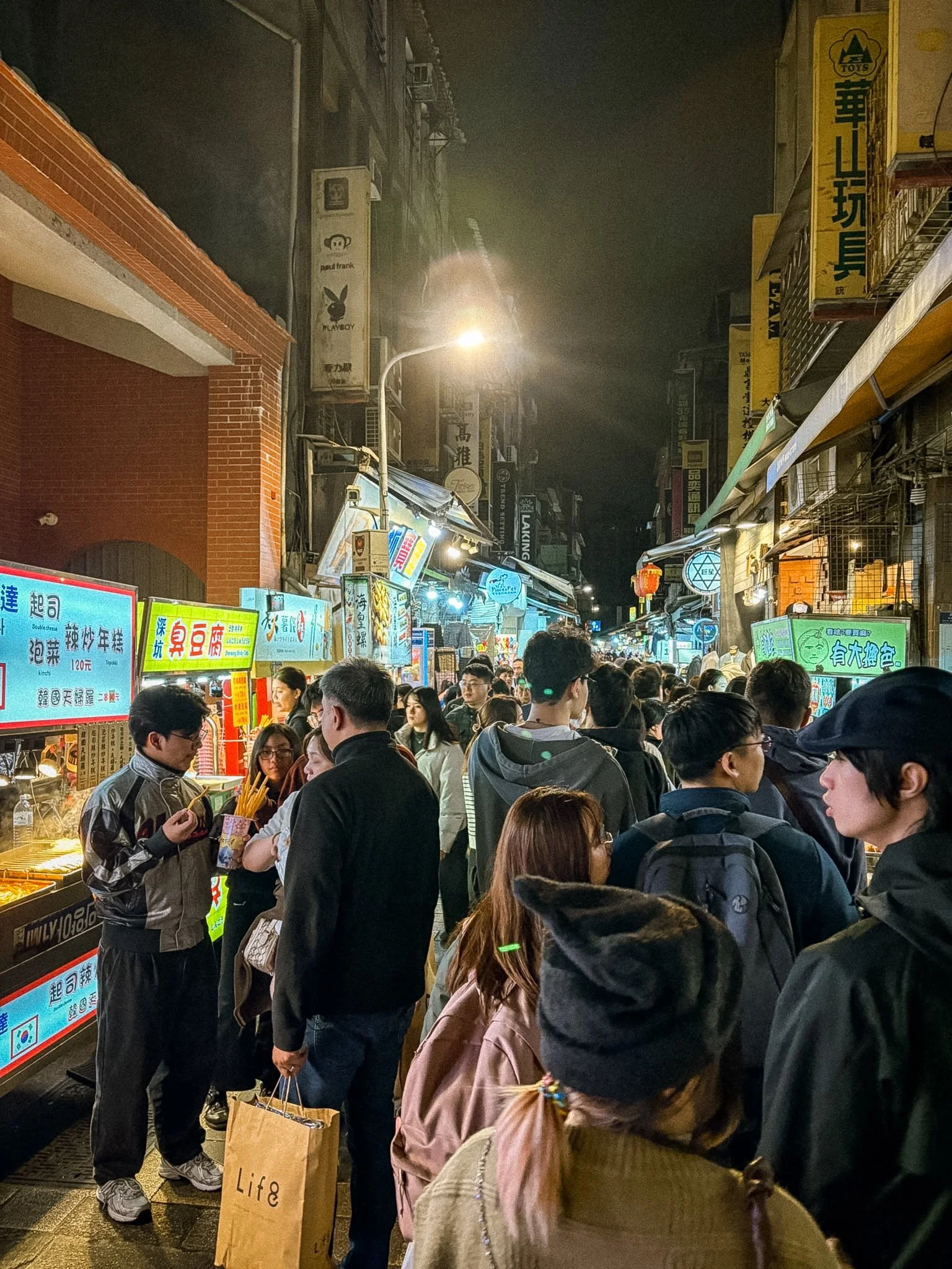 Busy walkway packed with visitors and street food vendors at Shilin Night Market in Taipei, Taiwan