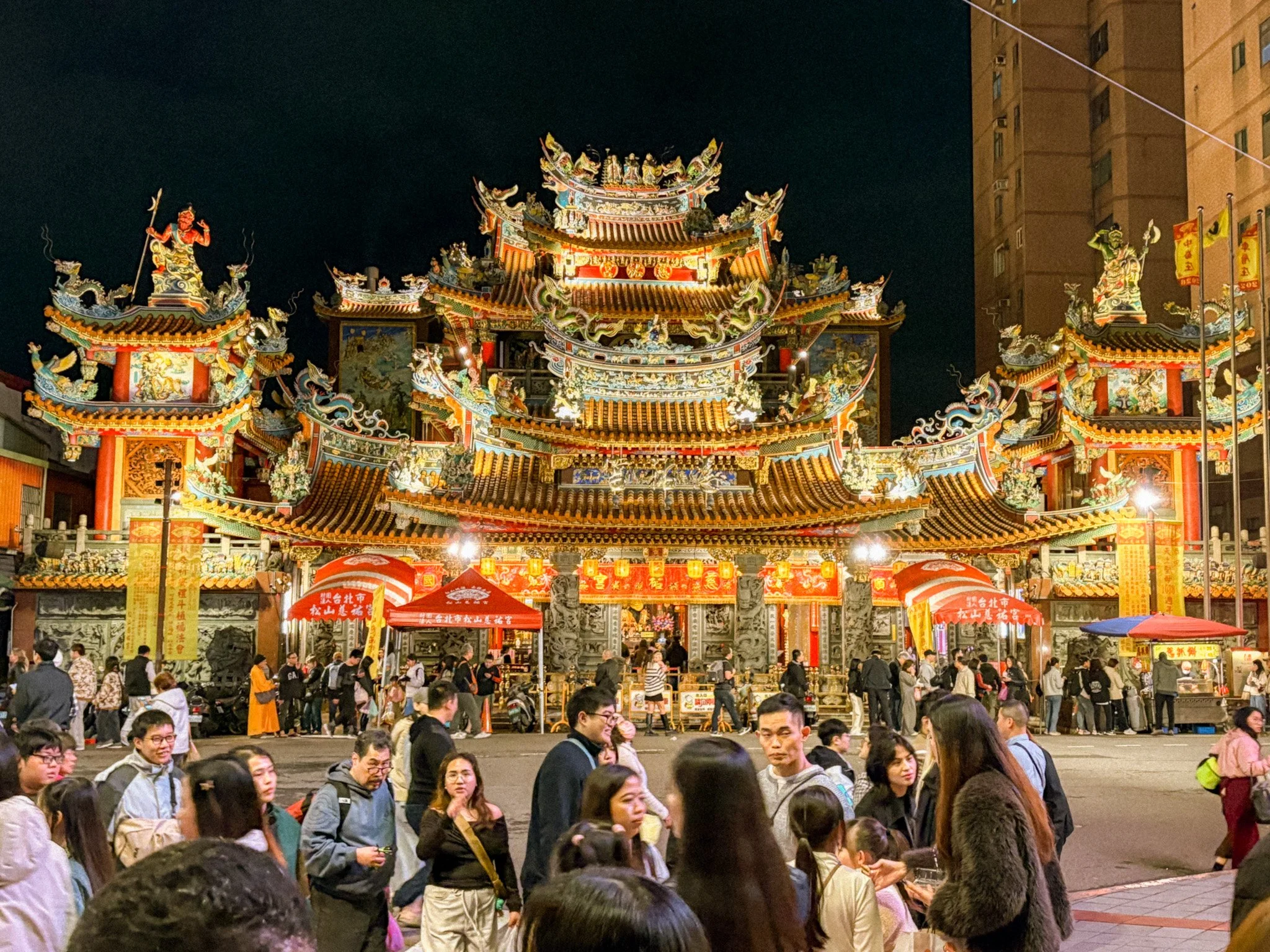 Exterior of Songshan Ciyou Temple illuminated at night near Raohe Market