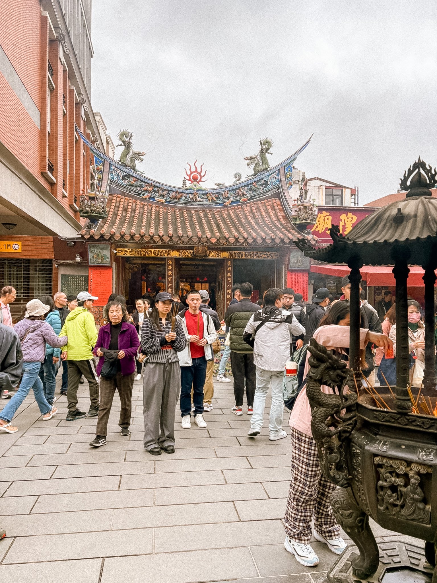 Xiahai City God Temple Taipei with visitors praying, incense smoke, and bustling crowd in Dadaocheng