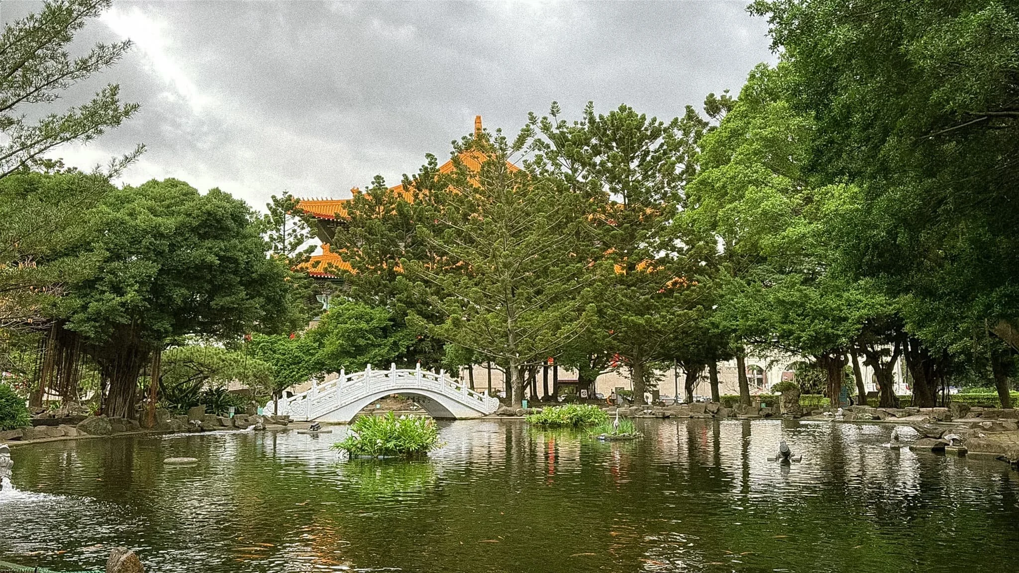White arched bridge over a koi pond in the gardens at Chiang Kai-Shek Memorial Hall