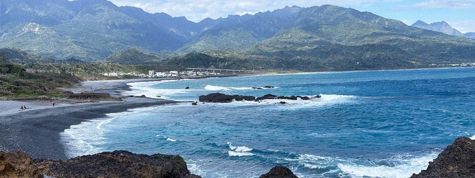 Coastal view of Taitung County, Taiwan, with mountains, pebble beach, and Pacific waves